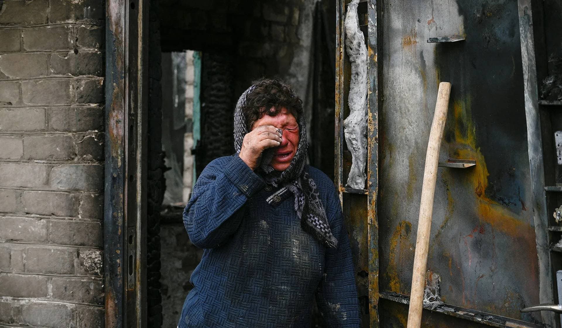 Resident reacts next to her house heavily damaged during a Russian military strike in Hirske