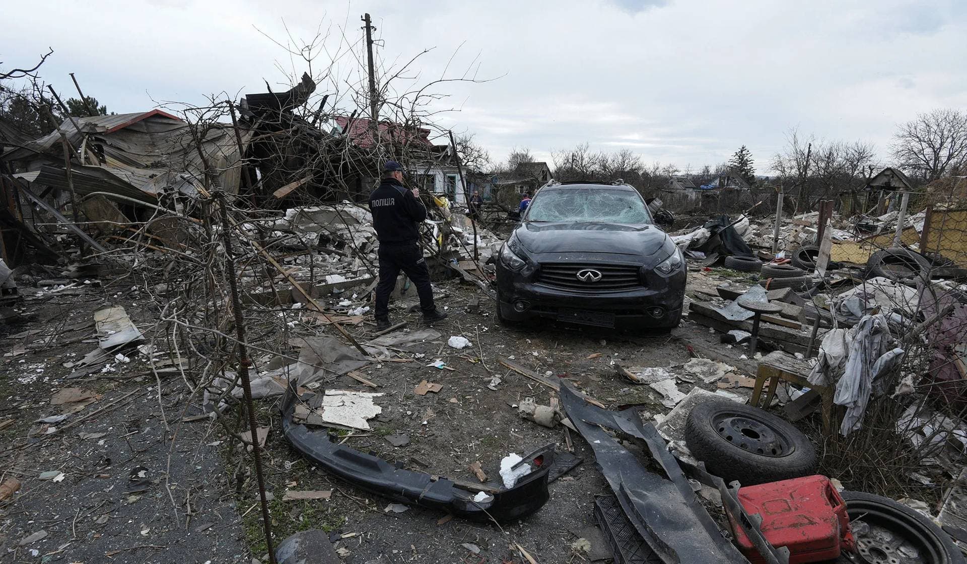 A police officer inspects a residential area heavily damaged during a Russian missile and drone strike in the city of Kamianske