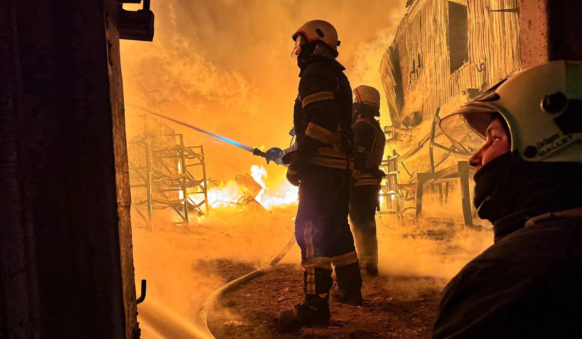 Firefighters work at a site of a Russian drone strike in Kharkiv