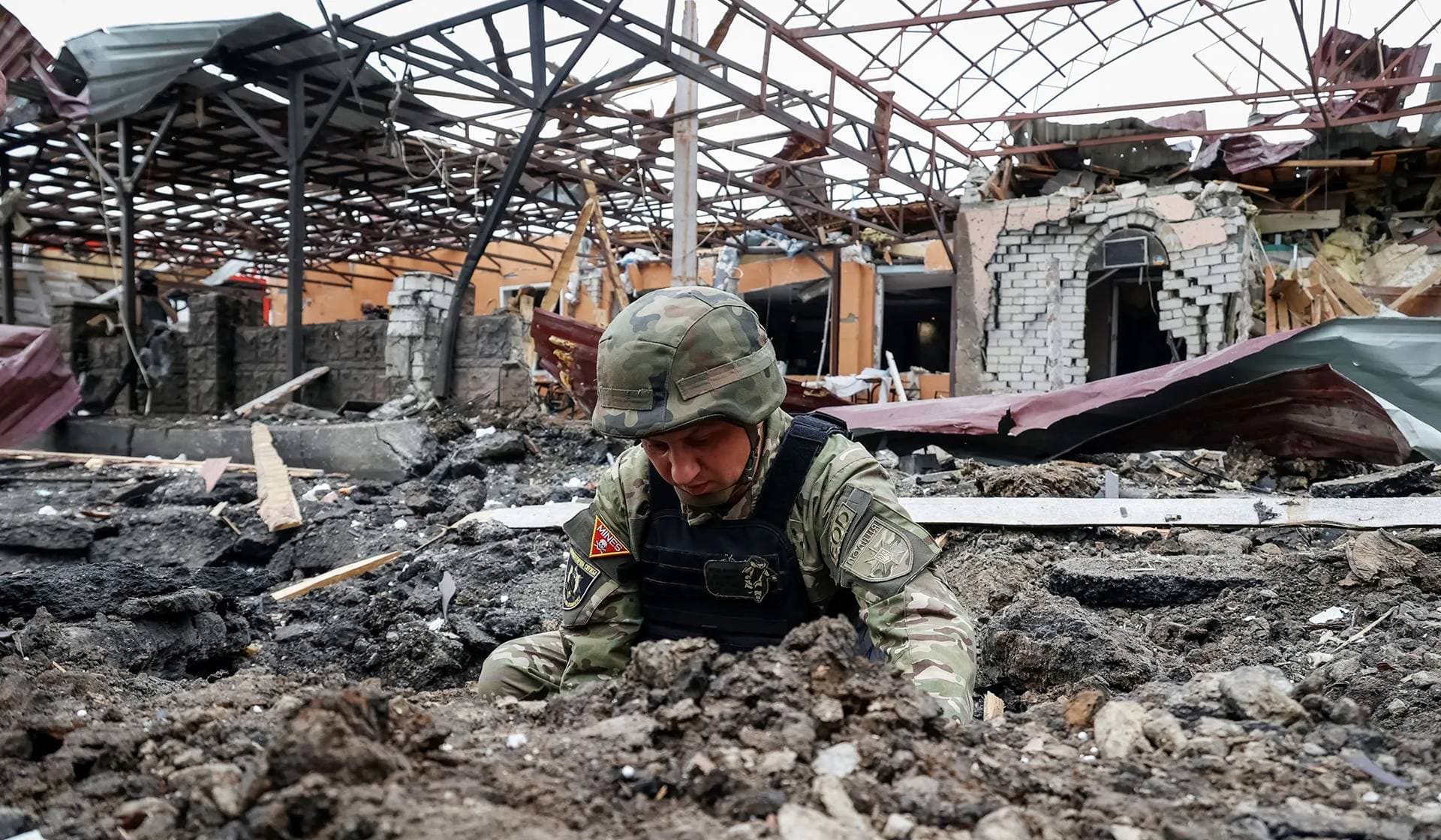 A police bomb squad member works at the site of a Russian air strike in Kharkiv