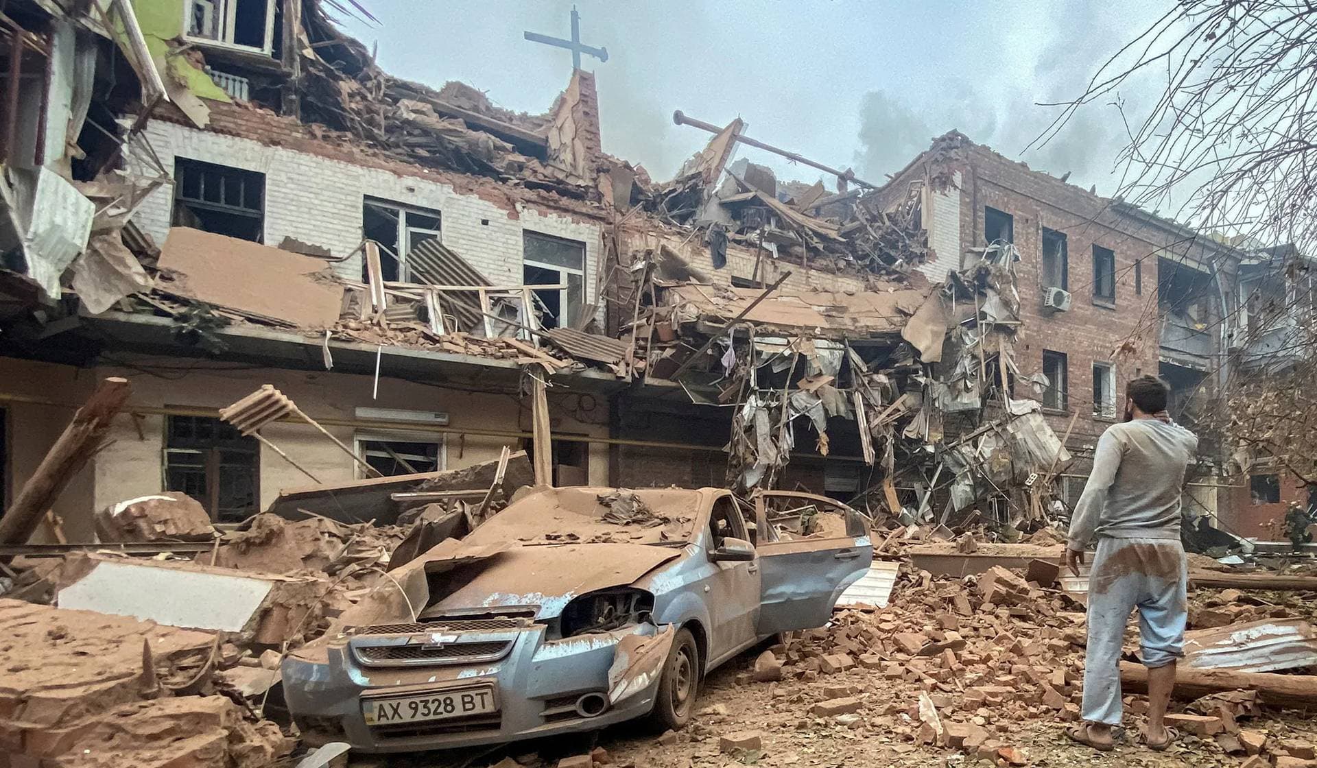 local resident looks at a residential building damaged by a Russian missile strike in Kharkiv