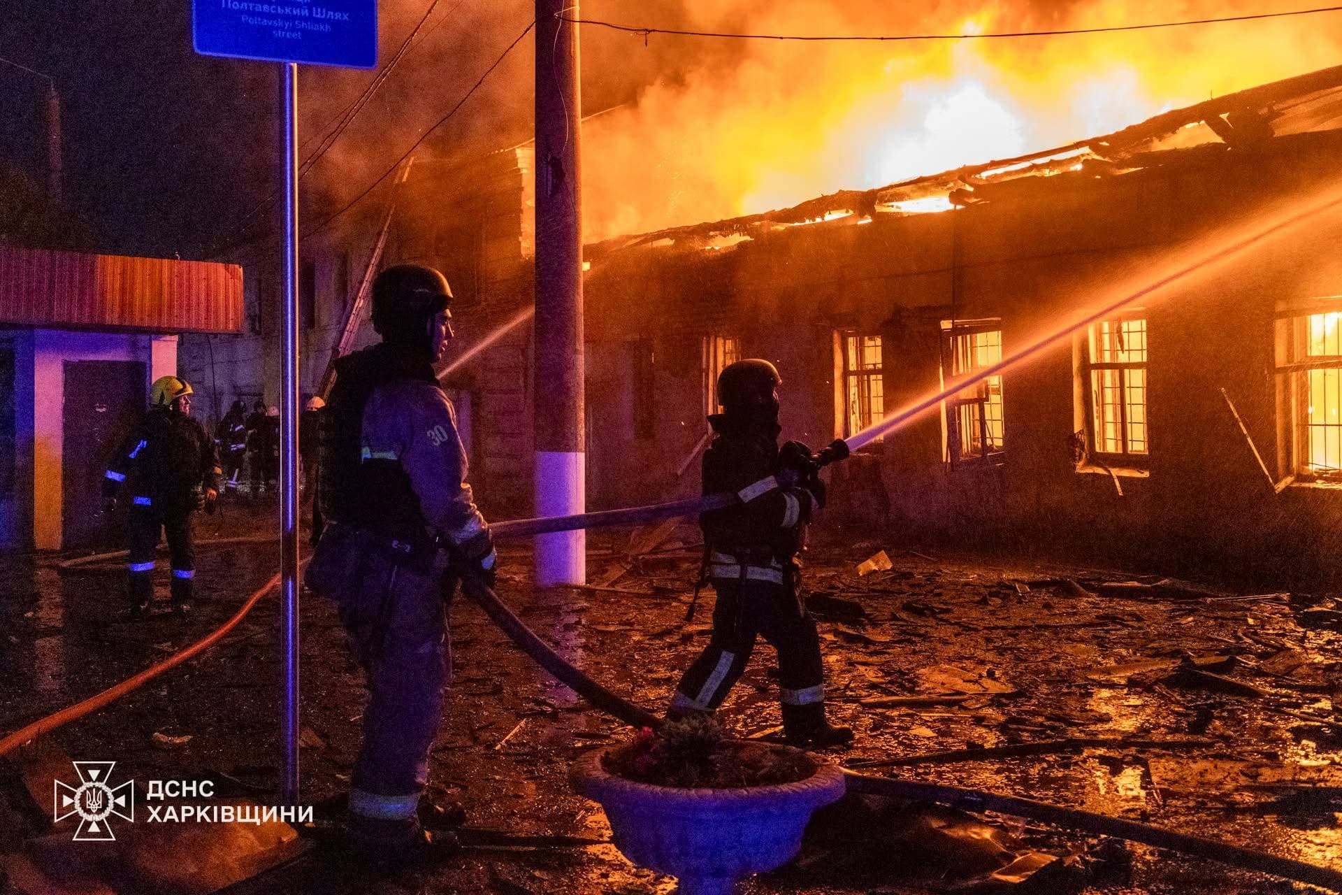 Firefighters work at the site of a building heavily damaged by a Russian drone strike in Kharkiv
