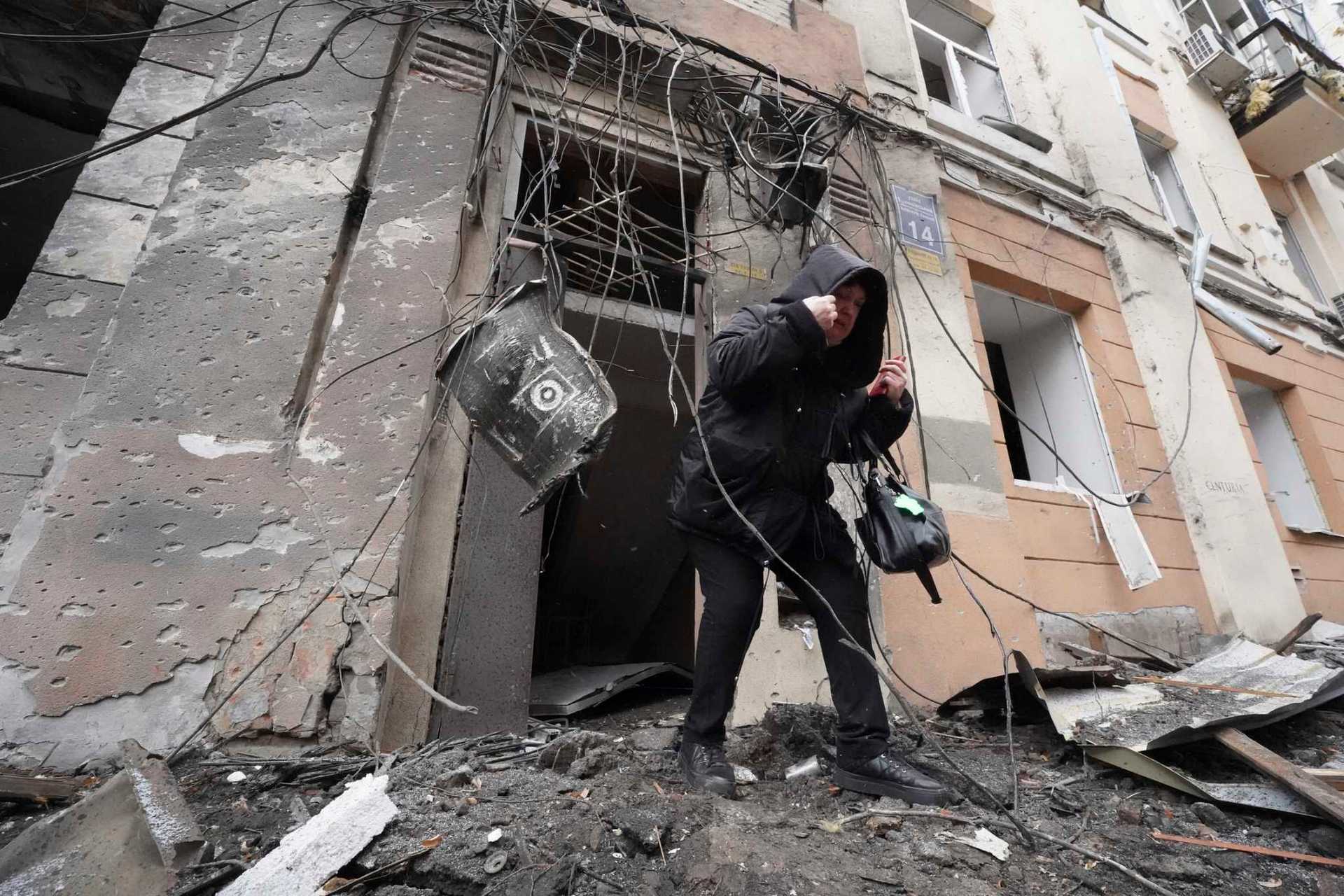 A woman walks out from a residential building which was hit by a Russian rocket, in the city center of Kharkiv