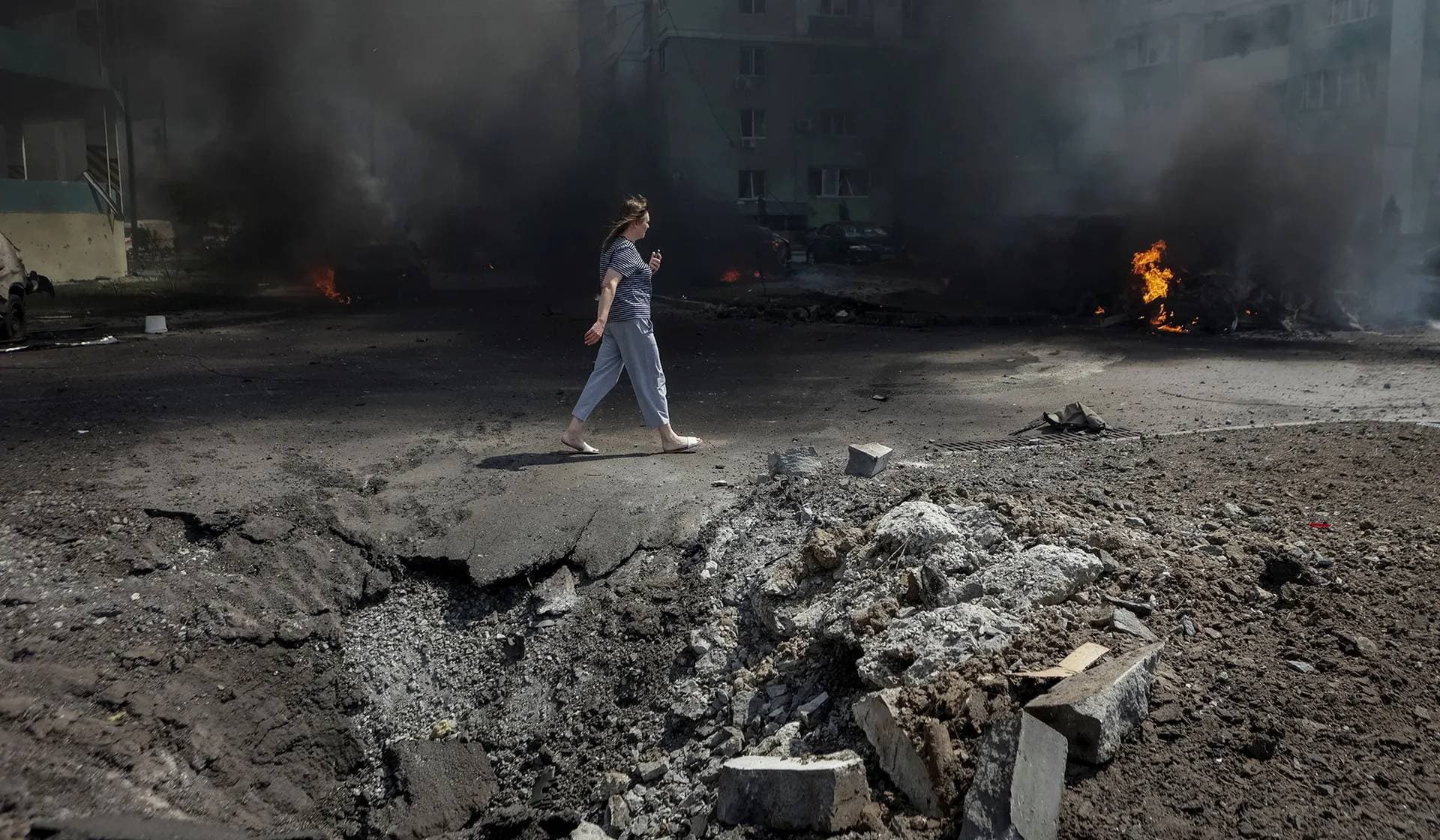A woman walks at the site of a Russian air strike in Kharkiv