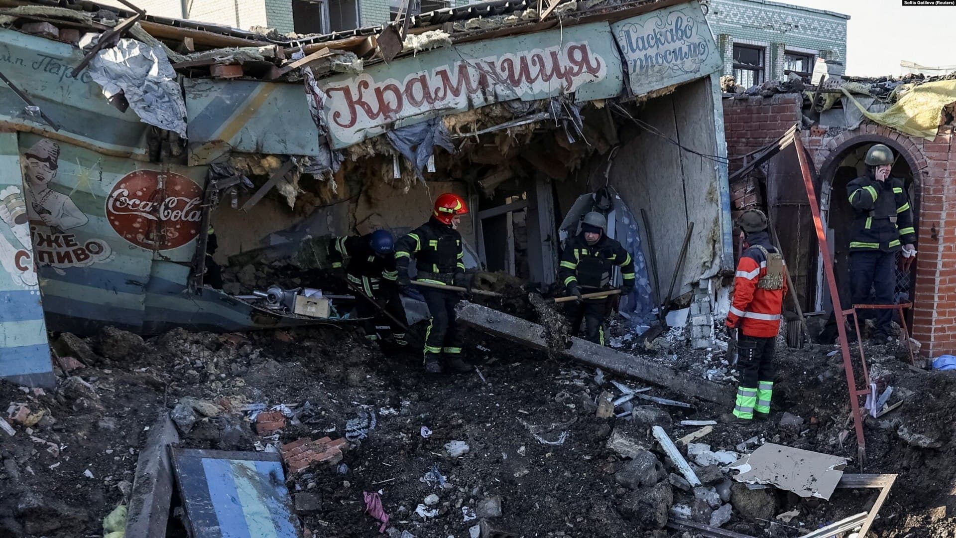 Ukrainian firefighters work at the site of a local market heavily damaged by a Russian missile strike in Shevchenkove