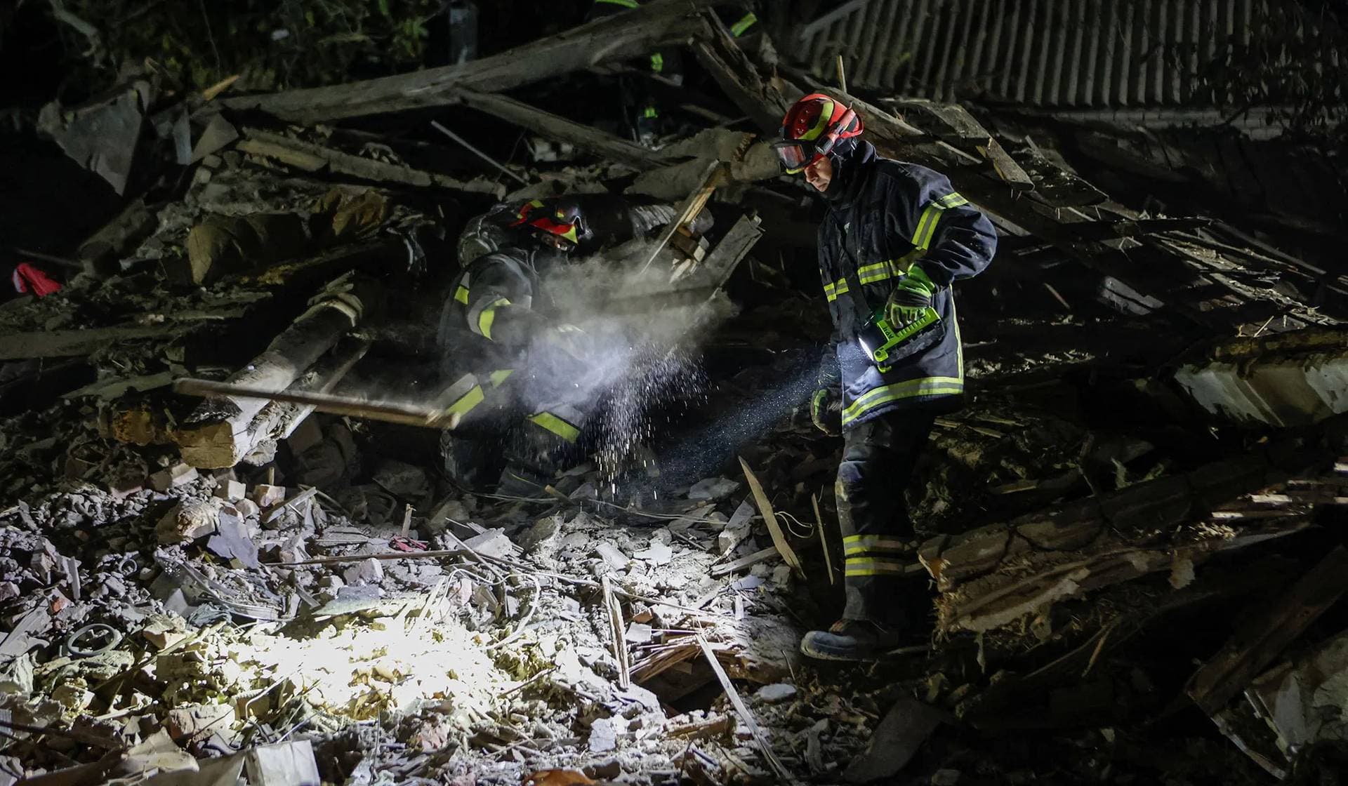 Rescuers work at a site of a private house which was hit by a Russian missile strike in Kharkiv
