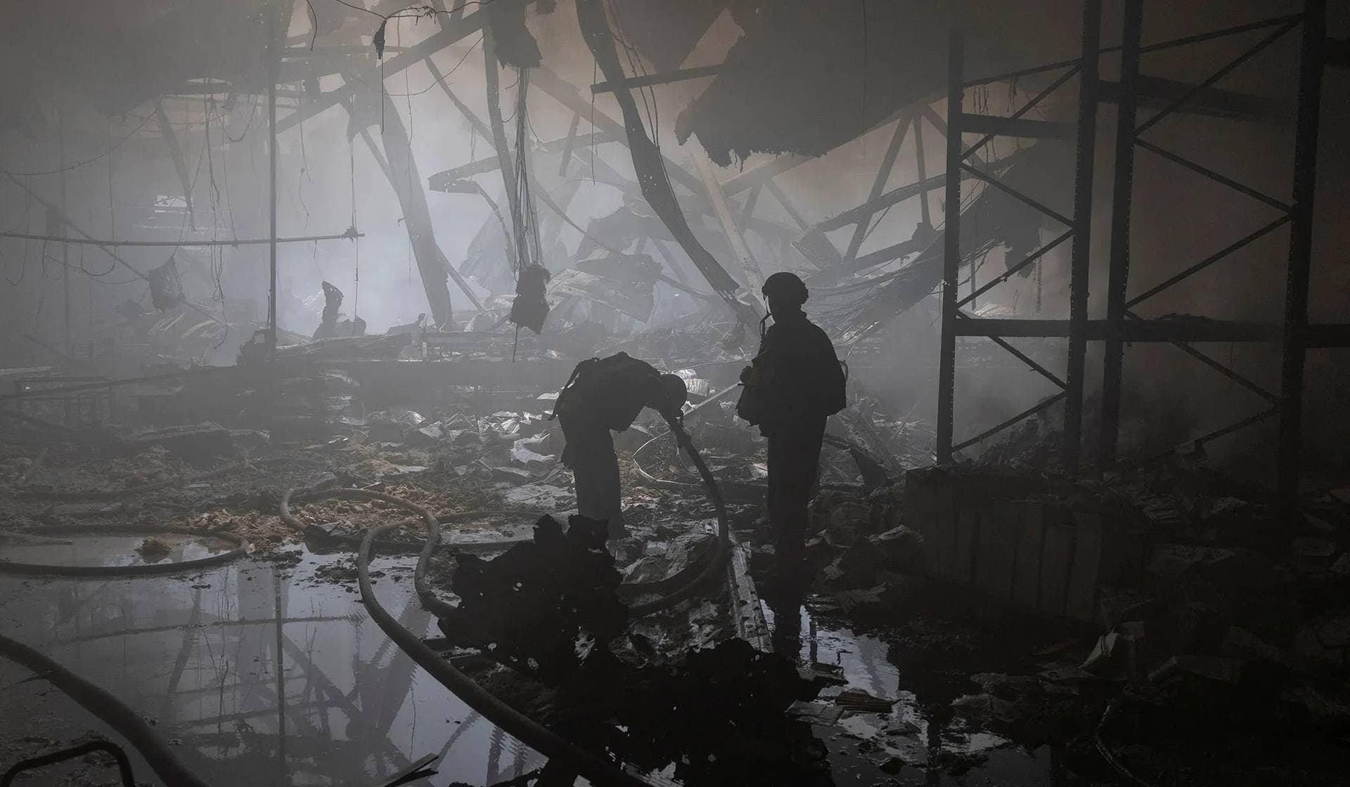 A firefighter washes up his face as he works at a compound of a printworks hit by Russian missile strikes in Kharkiv