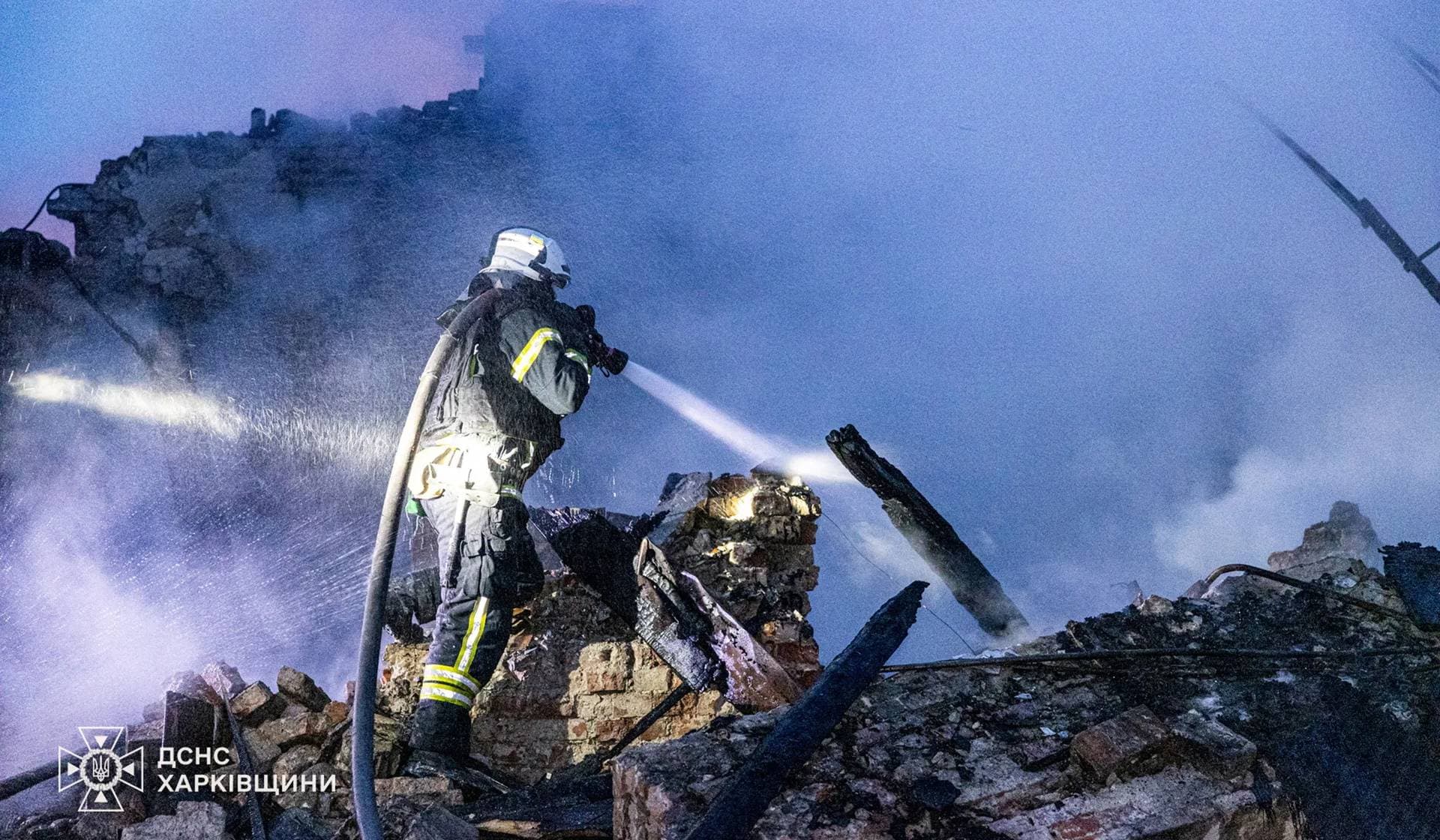Firefighters work at the site of a building heavily damaged by a Russian drone strike in Kharkiv