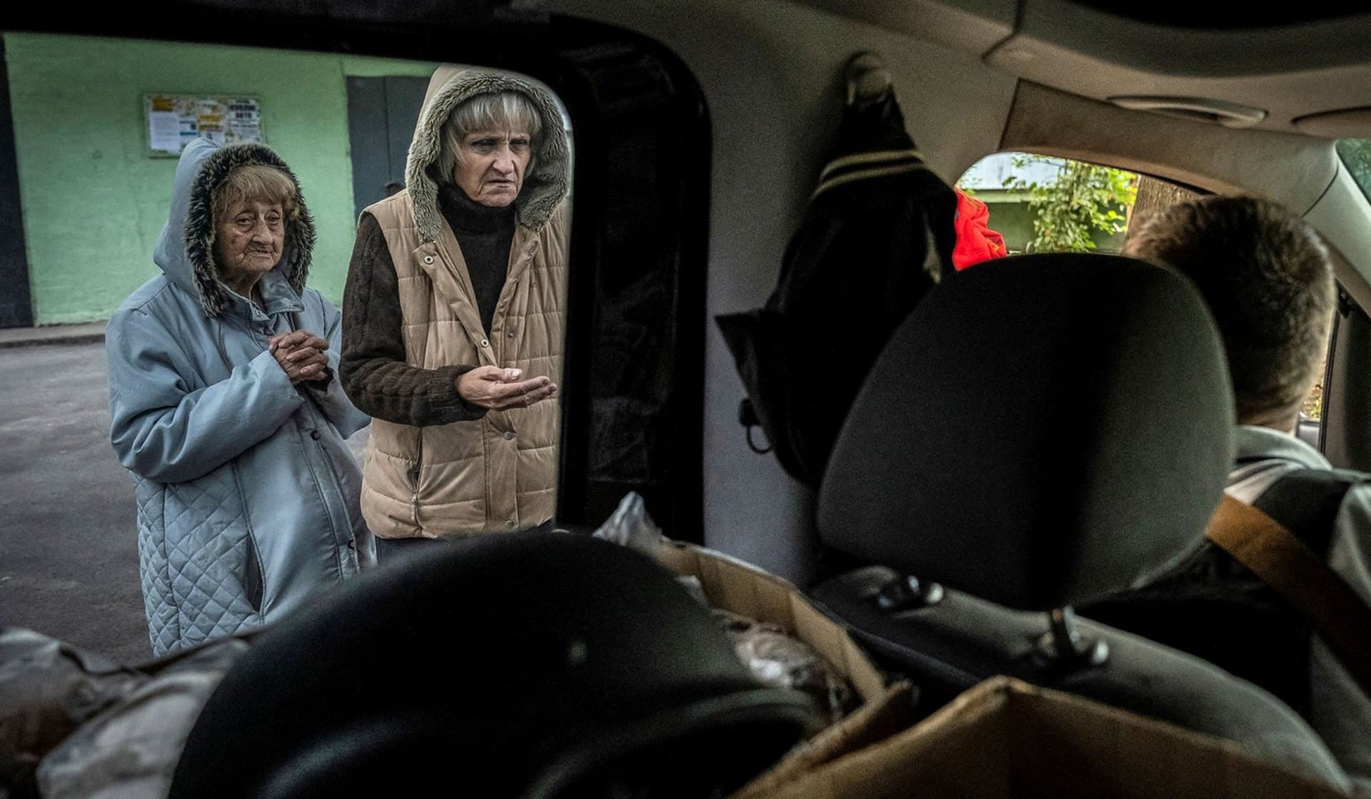 People line up for food handed out by volunteers in Saltivka