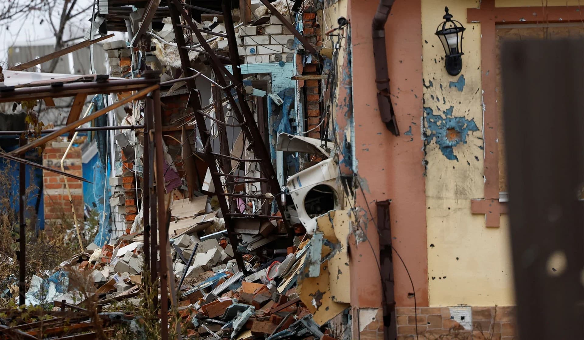 A washing machine hangs from a destroyed house in the village Tsupivka where Myhaylo Yurkiv stayed in his bunker for six months during fierce battles under Russian occupation