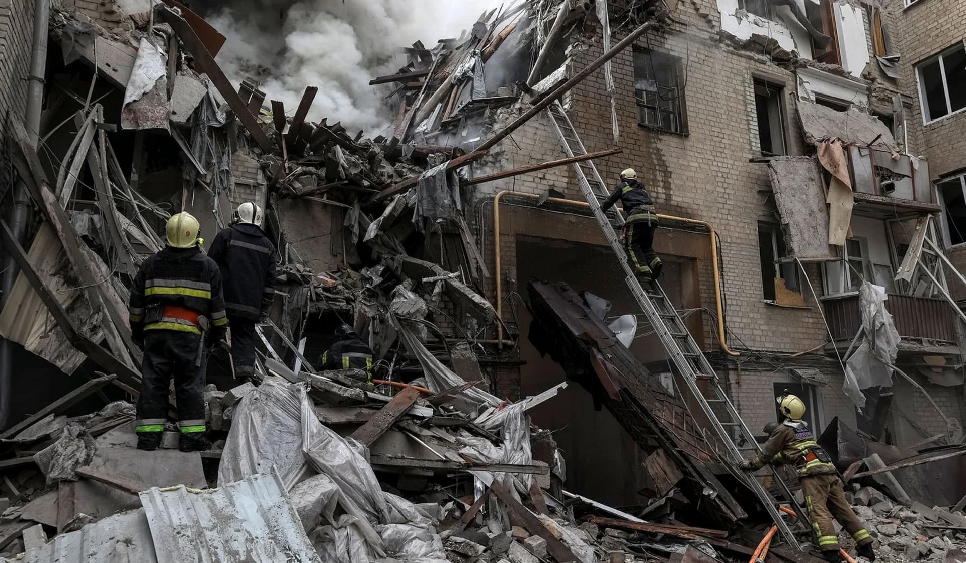 Firefighters work at the site of a residential building hit by a Russian military strike in Kharkiv