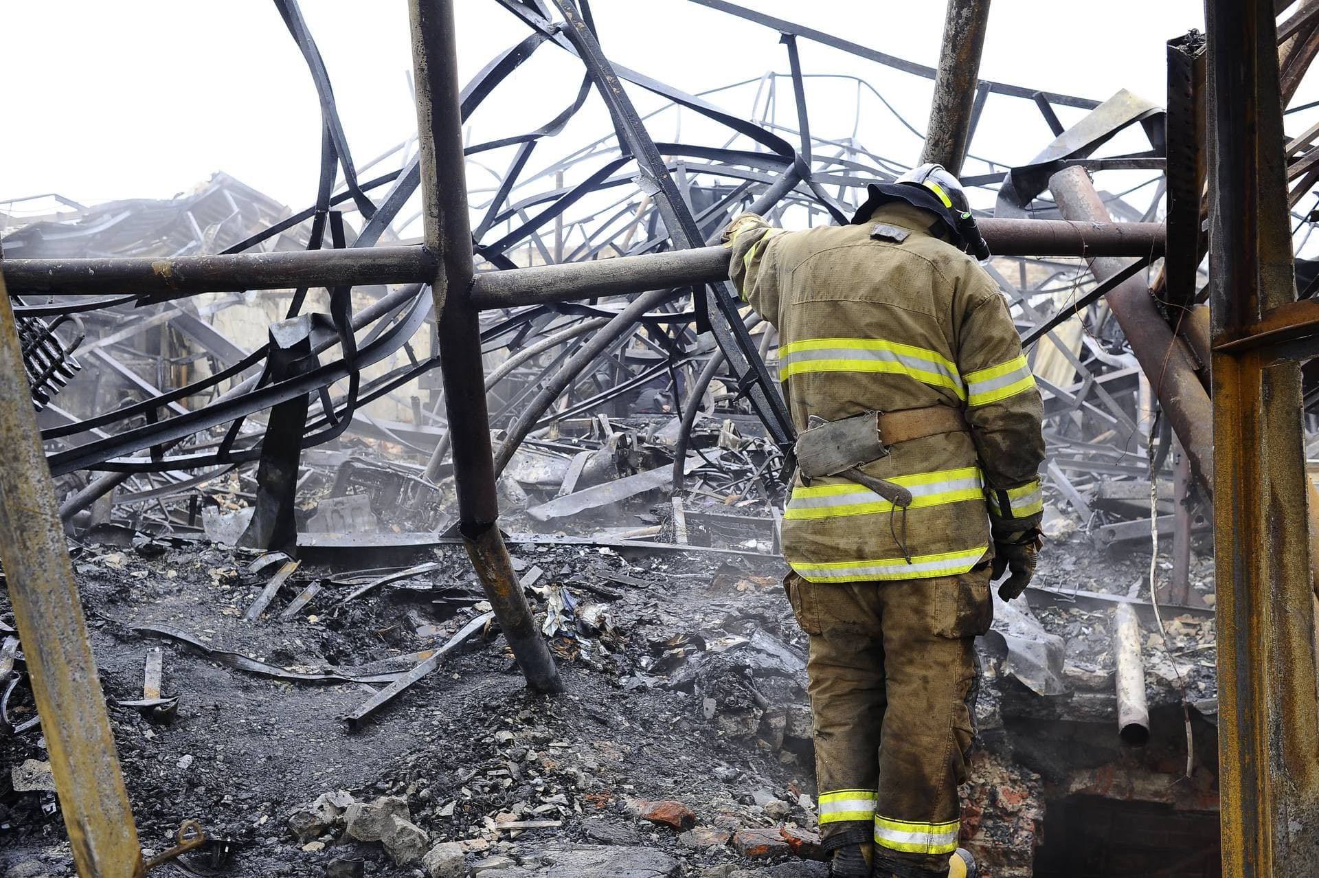 A firefighter stands at the site of a destroyed building after a Russian kamikaze drone attack in Kharkiv