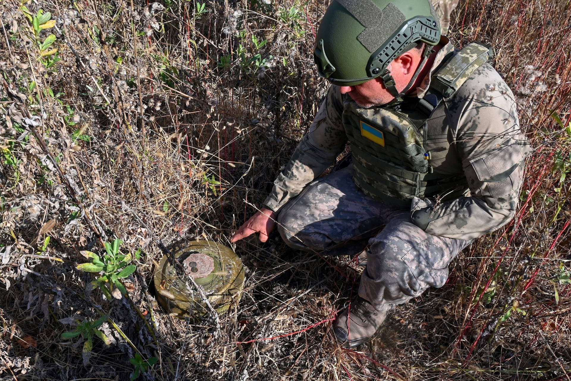Roman Hekalyuk examines a TM-62M anti-tank mine near the town of Derhachi