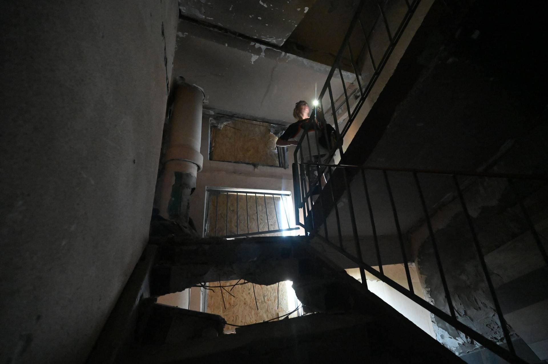 Tetiana Bezatosna walks in the destroyed building she once called home