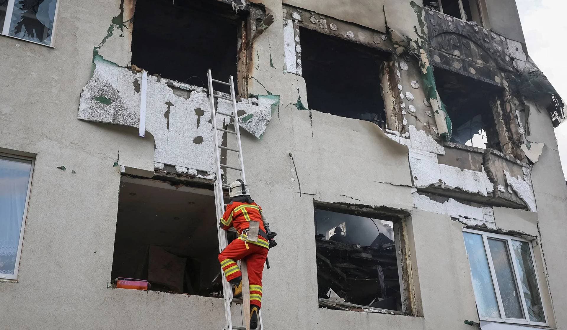 A firefighter works at the site of an apartment building hit by a Russian drone strike in Kharkiv