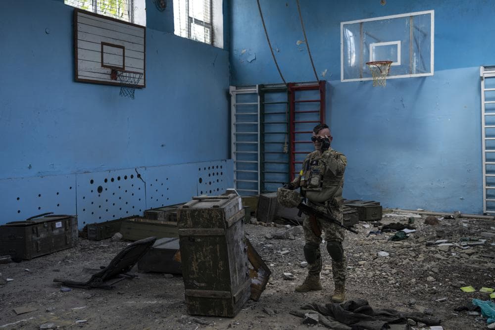 A Ukrainian serviceman inspects a school damaged during a battle between Russian and Ukrainian forces in the village of Vilkhivka, on the outskirts of Kharkiv