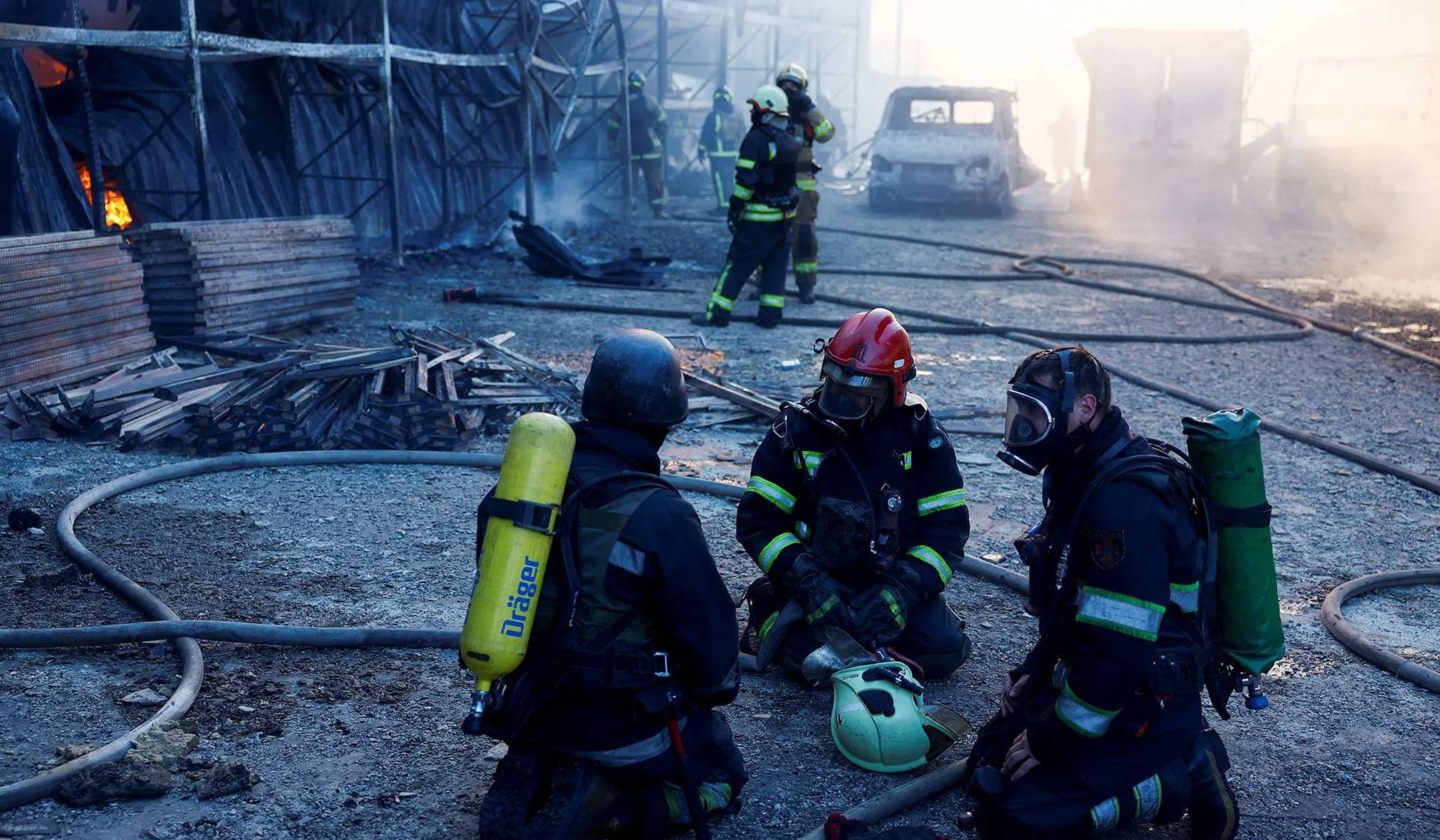 Firefighters work at the site of a household item shopping mall hit by a Russian air strike in Kharkiv