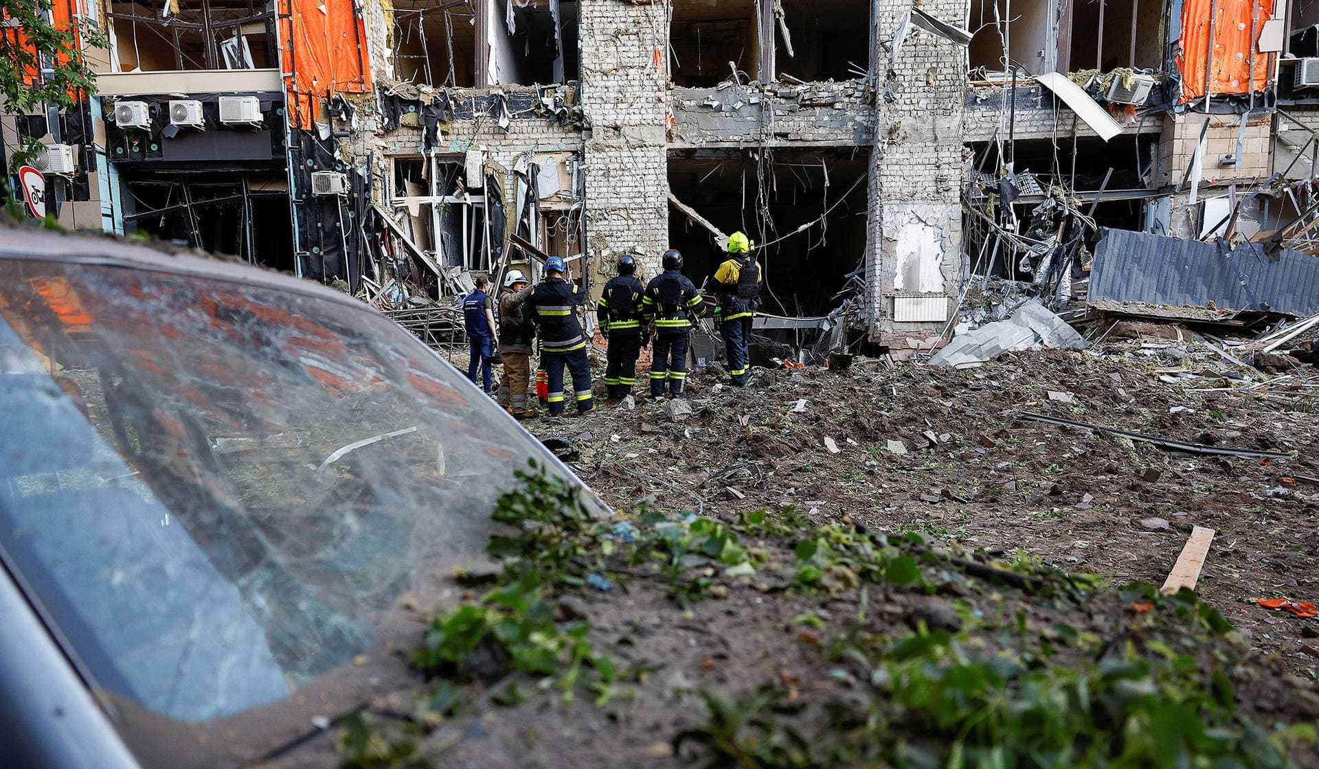Firefighters work at the site of an office building hit by a Russian air strike in Kharkiv