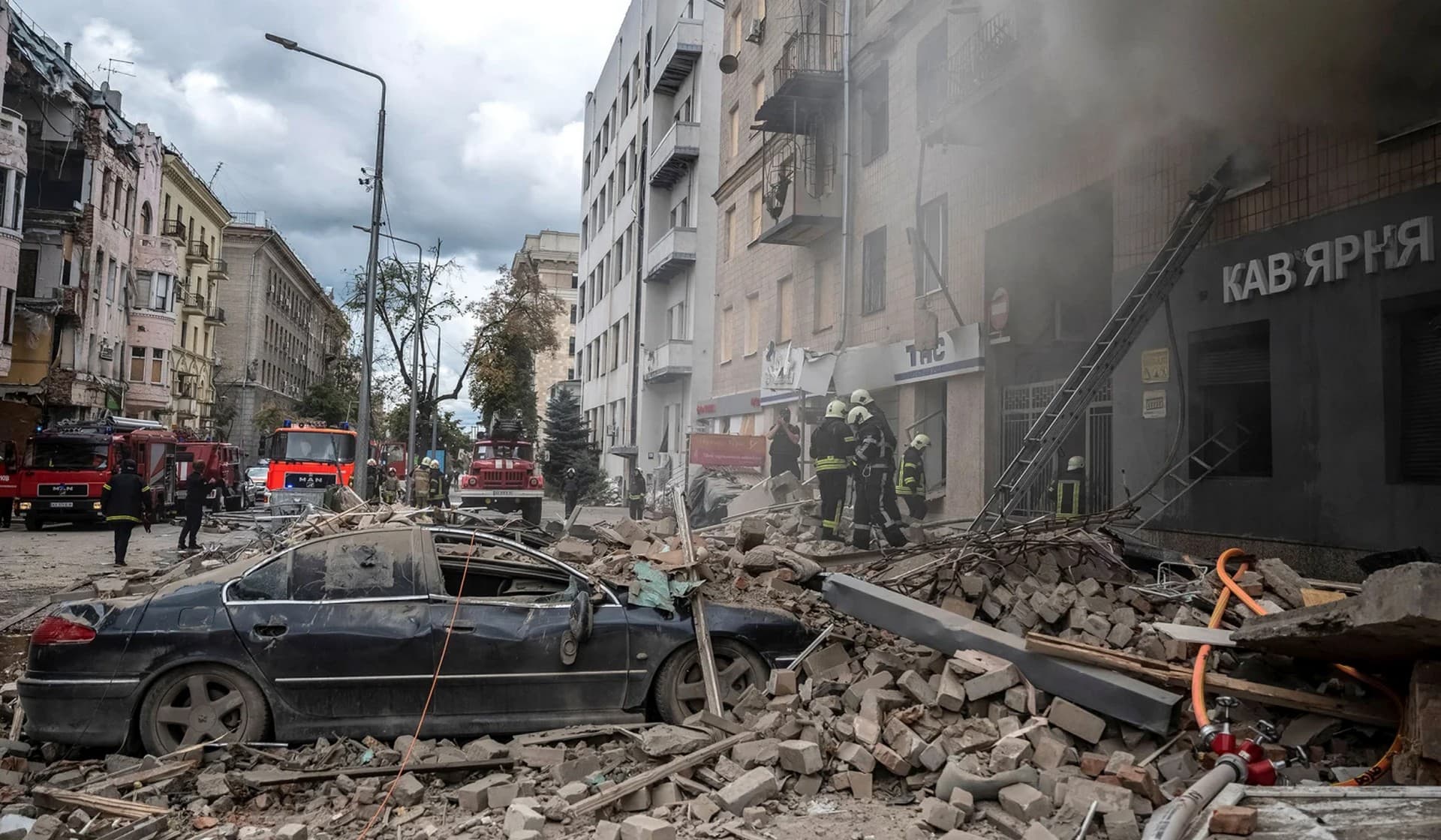 Firefighters work at the site of a residential building hit by a Russian military strike in Kharkiv