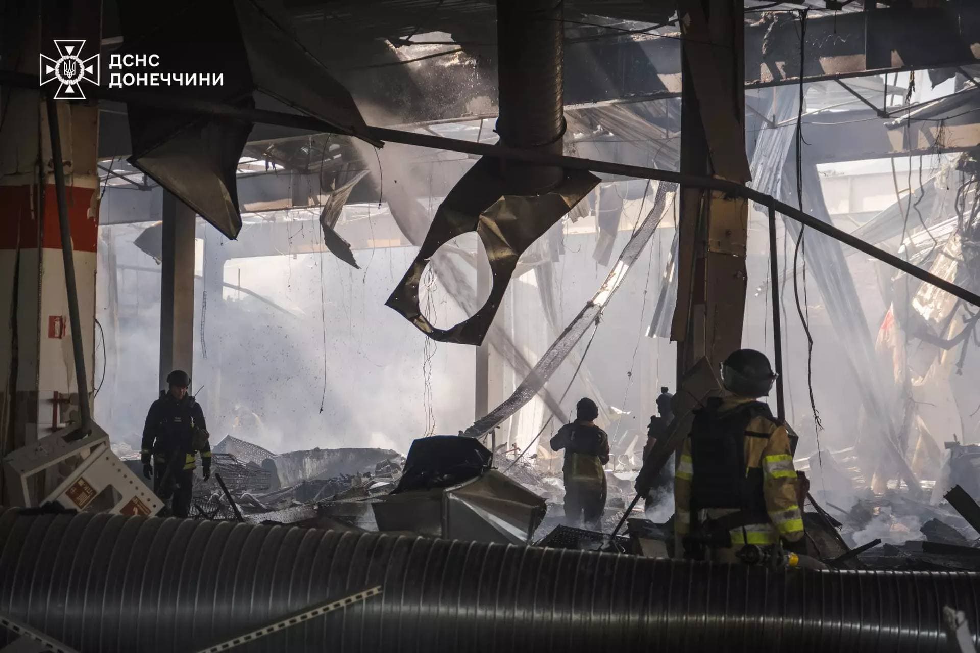 Firefighters work inside a supermarket heavily damaged by a Russian military strike in Kostiantynivka