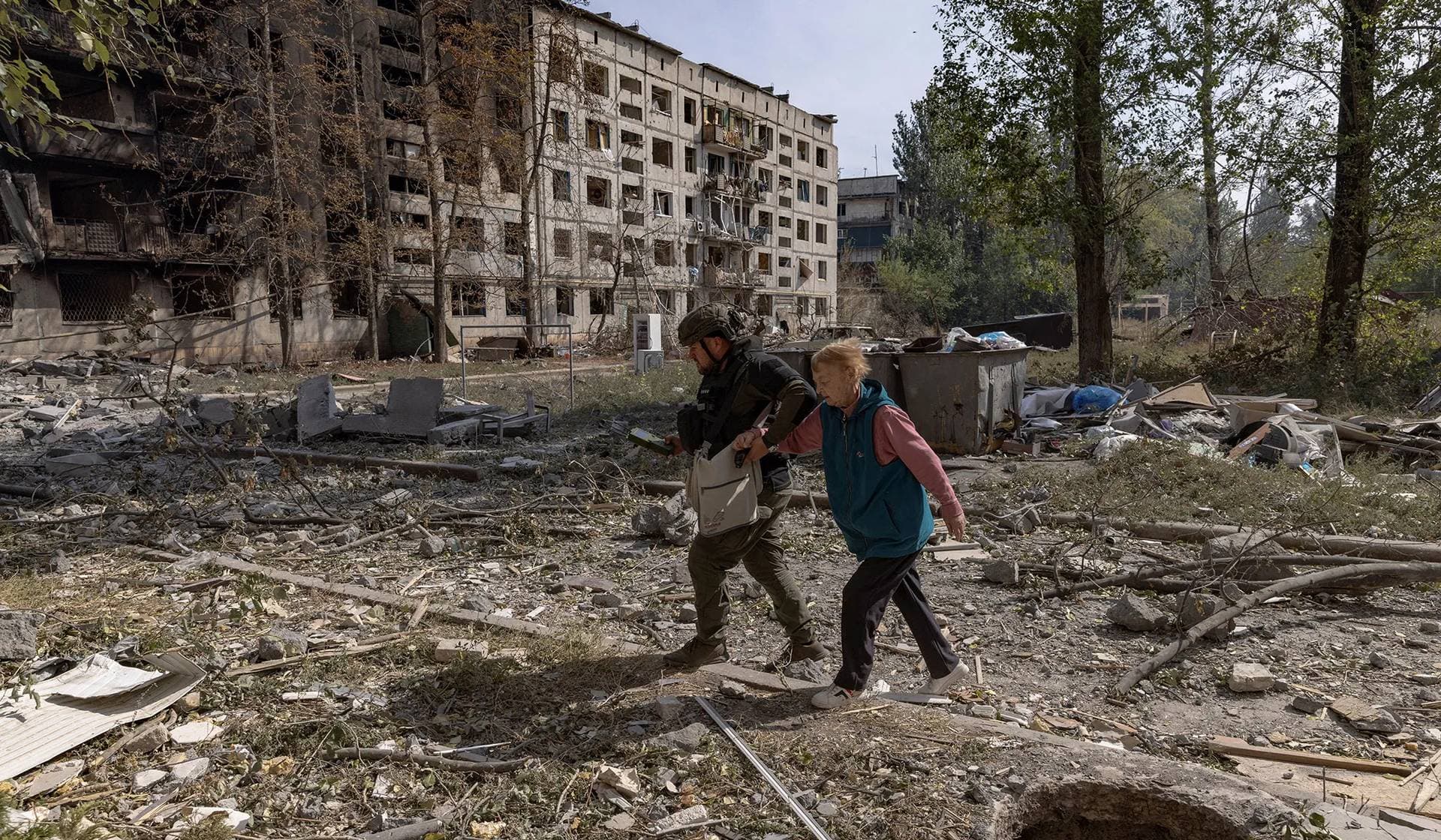 A member of the White Angels police evacuation unit assists a resident during an evacuation from the frontline town of Kostiantynivka