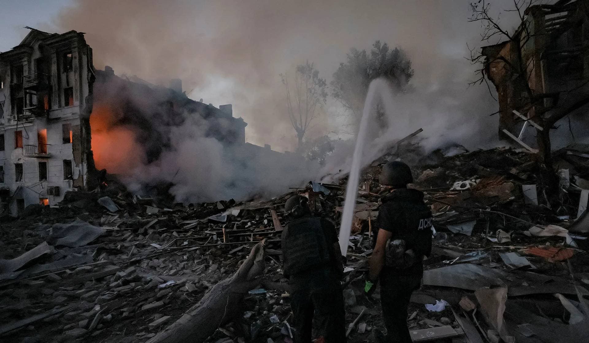 Firefighters work at the site of an apartment building hit by a Russian military strike in Kramatorsk