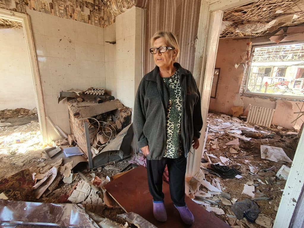 Olha Devich stands inside the destroyed home of her mother in law in Malotaranivka