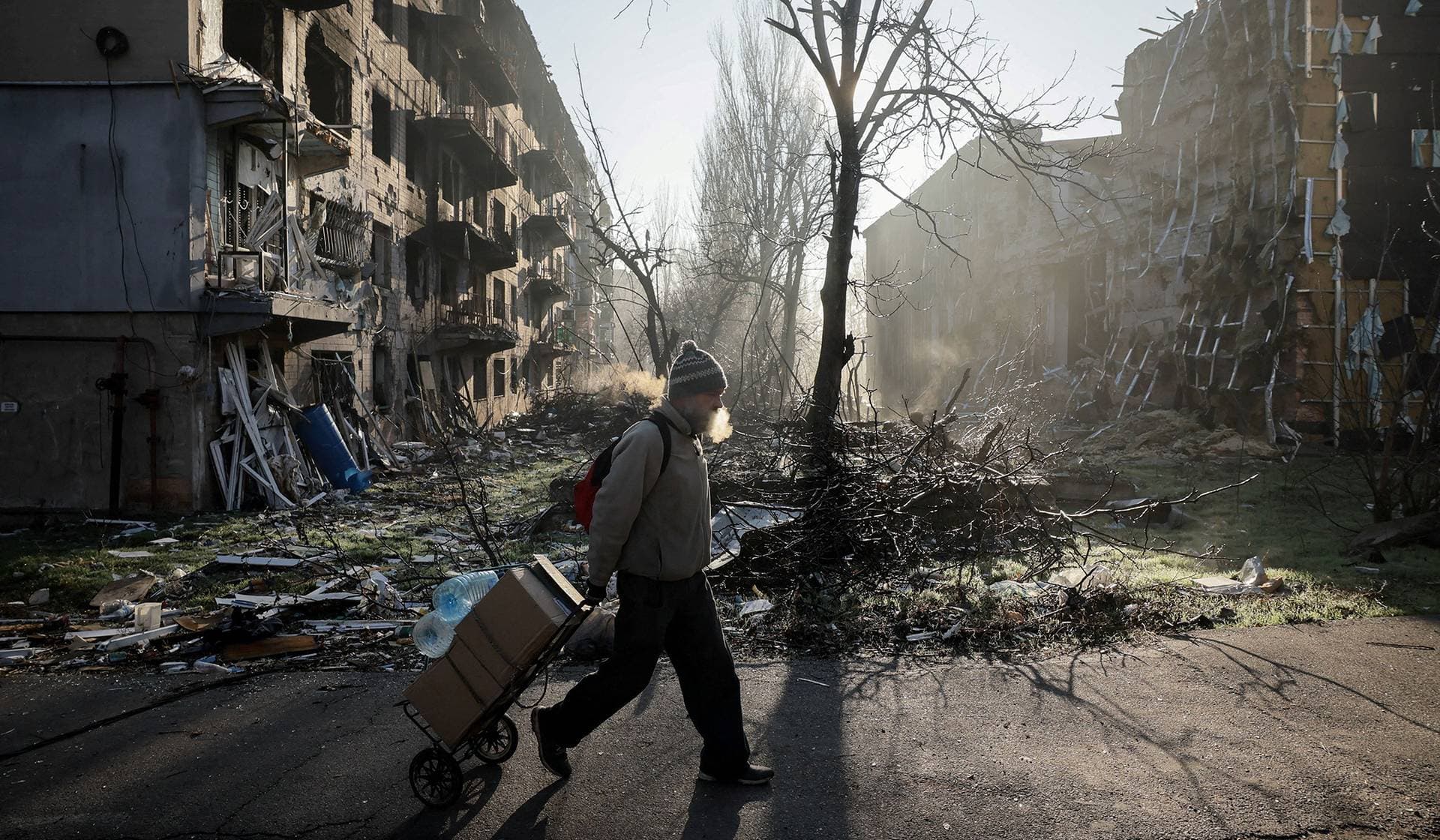 A resident walks near apartment buildings damaged by a Russian military strike in the frontline town of Kostiantynivka