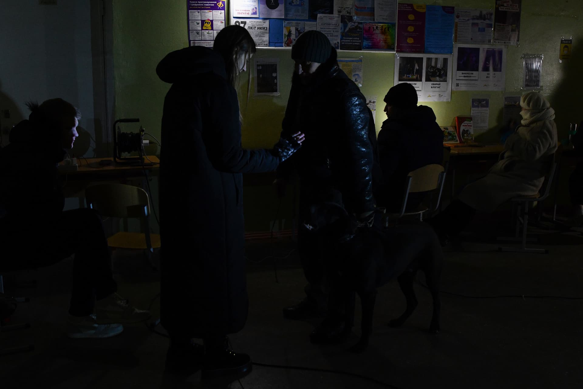 People charge their phones with the help of generators at a school building, a Point of Invincibility, in Kramatorsk