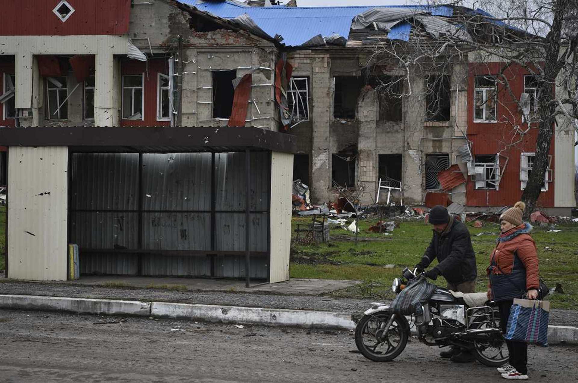 Local residents stands on the street in the village of Drobysheve