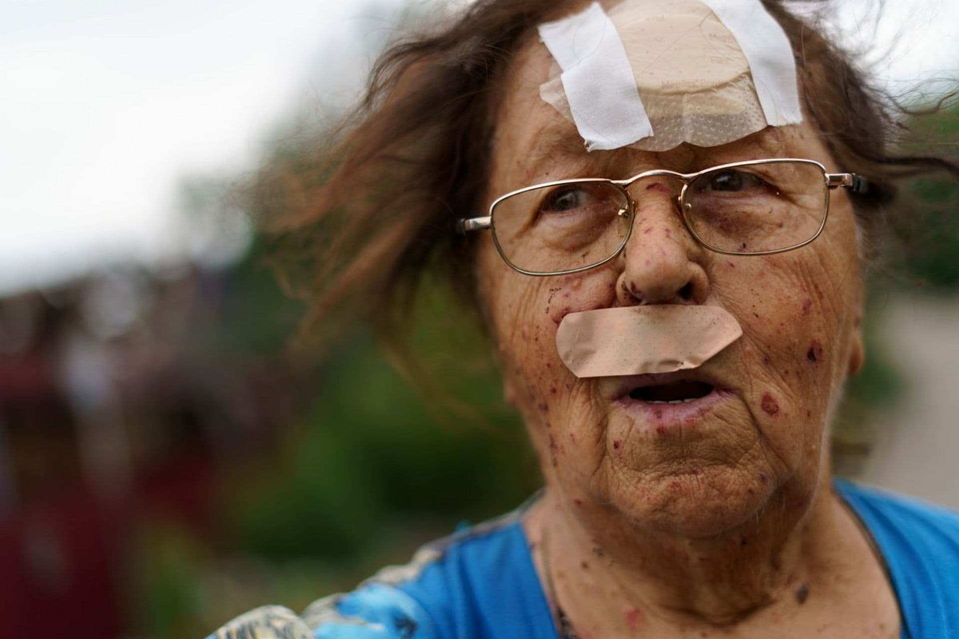 Valentyna Kondratieva stands outside her damaged home Saturday, Aug. 13, 2022 in Kramatorsk