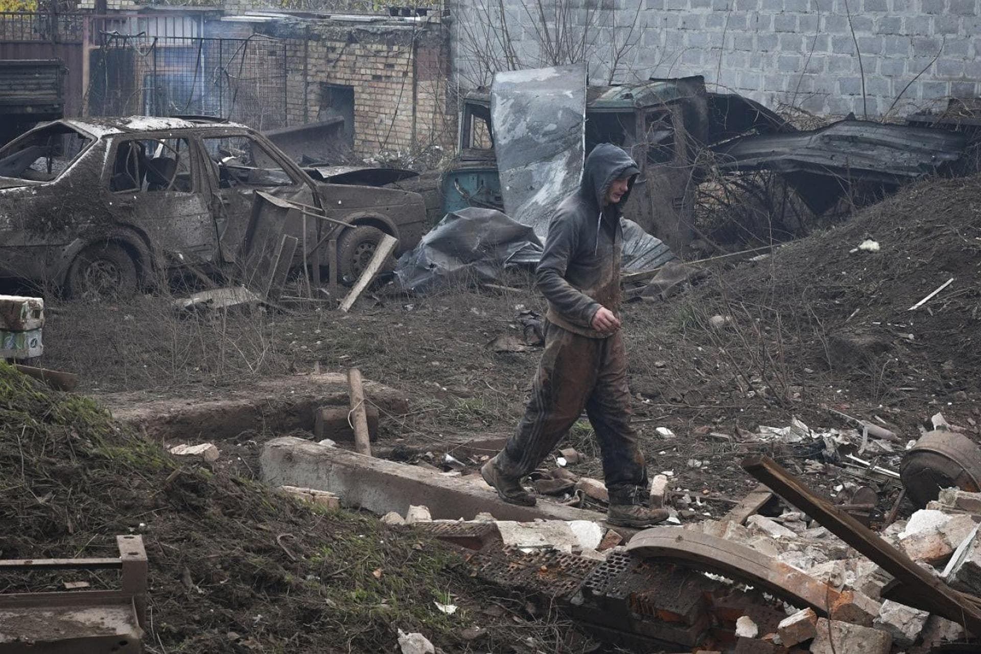 A local resident walks in yard of small business that was damaged after an overnight Russian attack in Kramatorsk