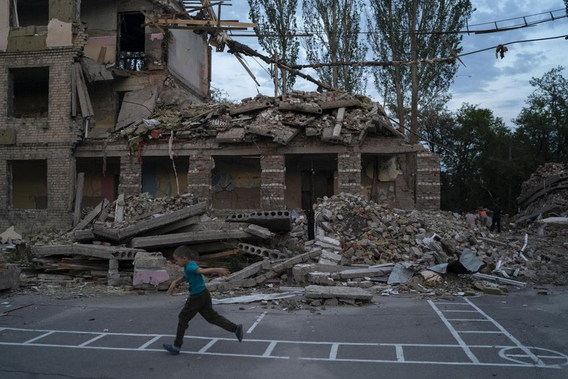 Oleksii Makarov plays in the courtyard of the destroyed School Number 23 in Kramatorsk