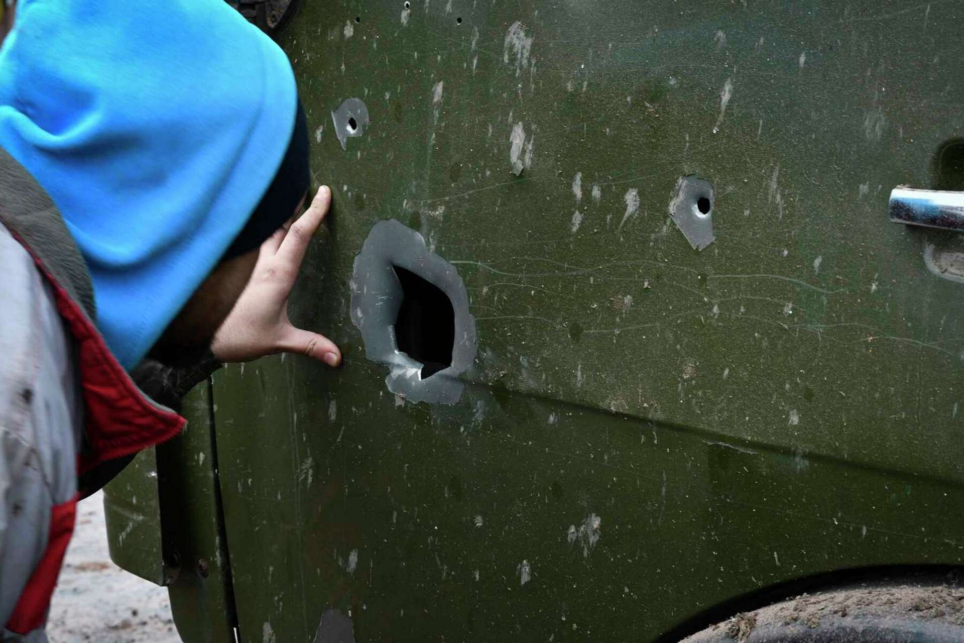 A local resident inspects a truck that was damaged after an overnight Russian attack in Kramatorsk