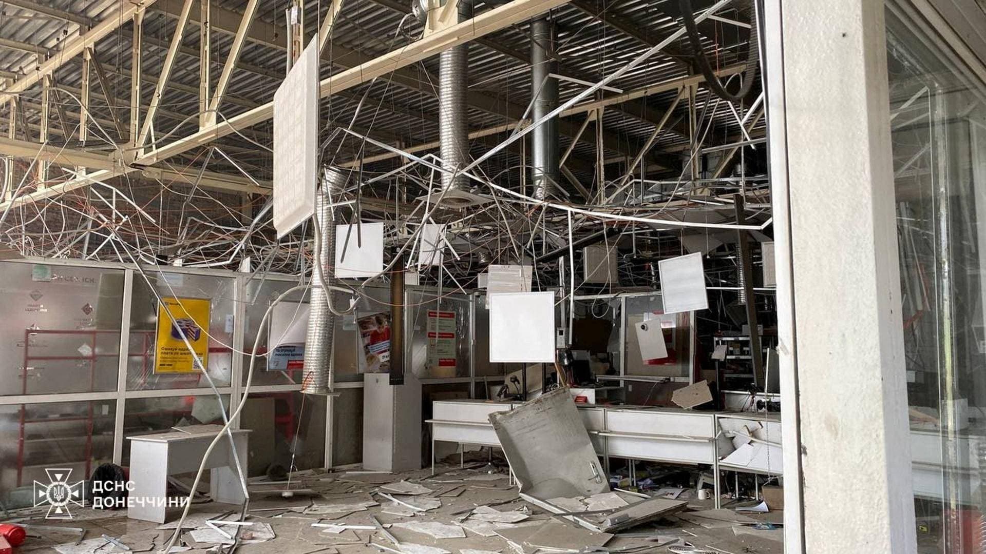 Firefighters work inside a supermarket heavily damaged by a Russian military strike in Kostiantynivka
