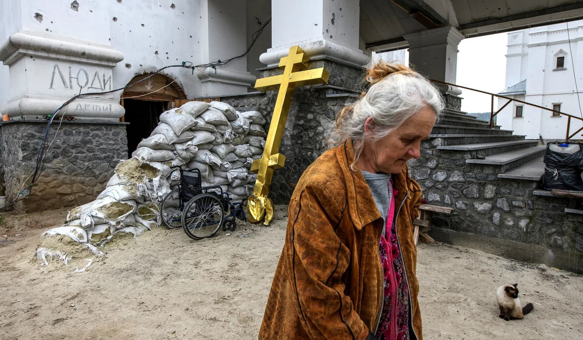 A woman walks at a compound of a damaged church in the town of Sviatohirsk