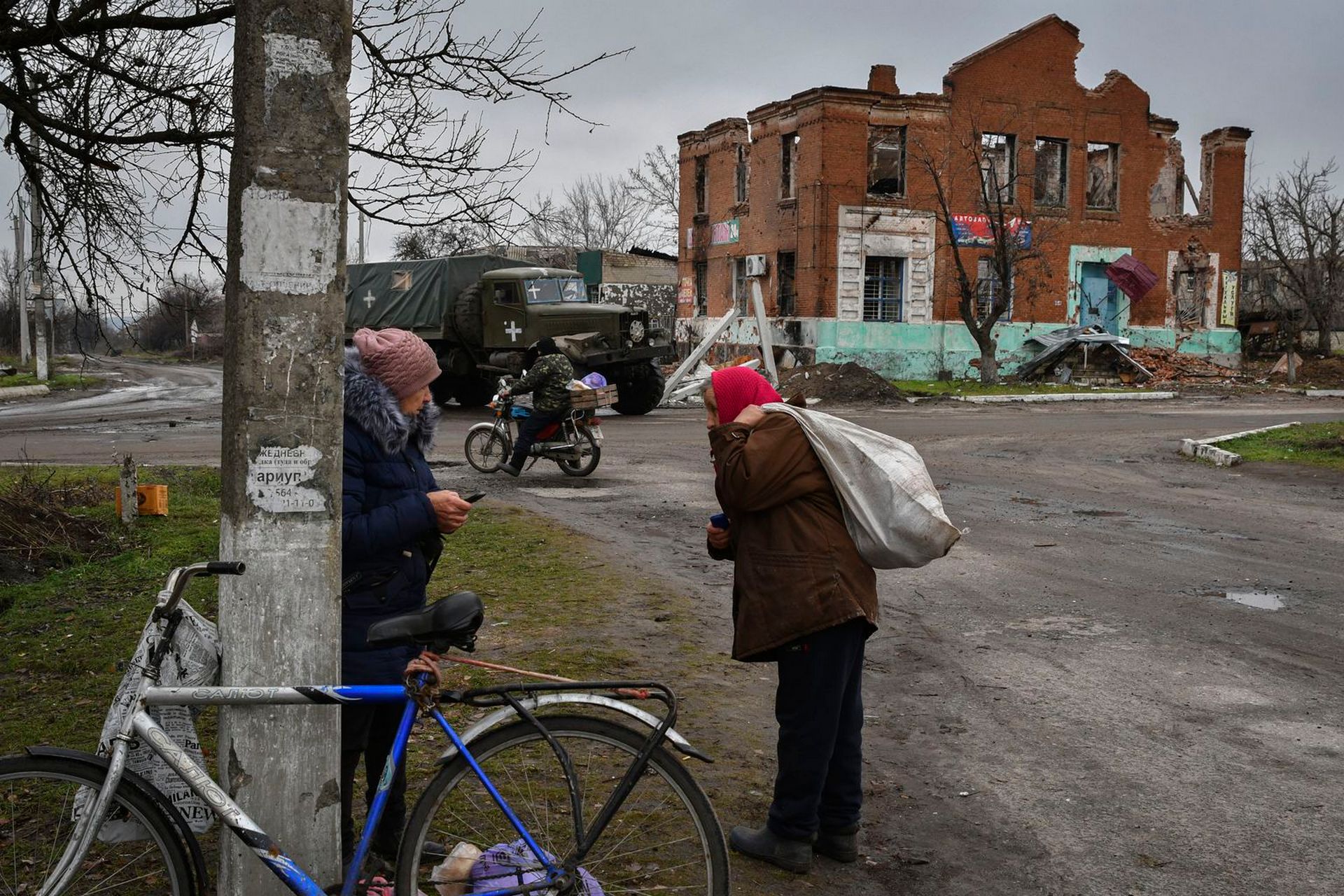 People carry food after receiving it at a humanitarian aid point in the village of Drobysheve