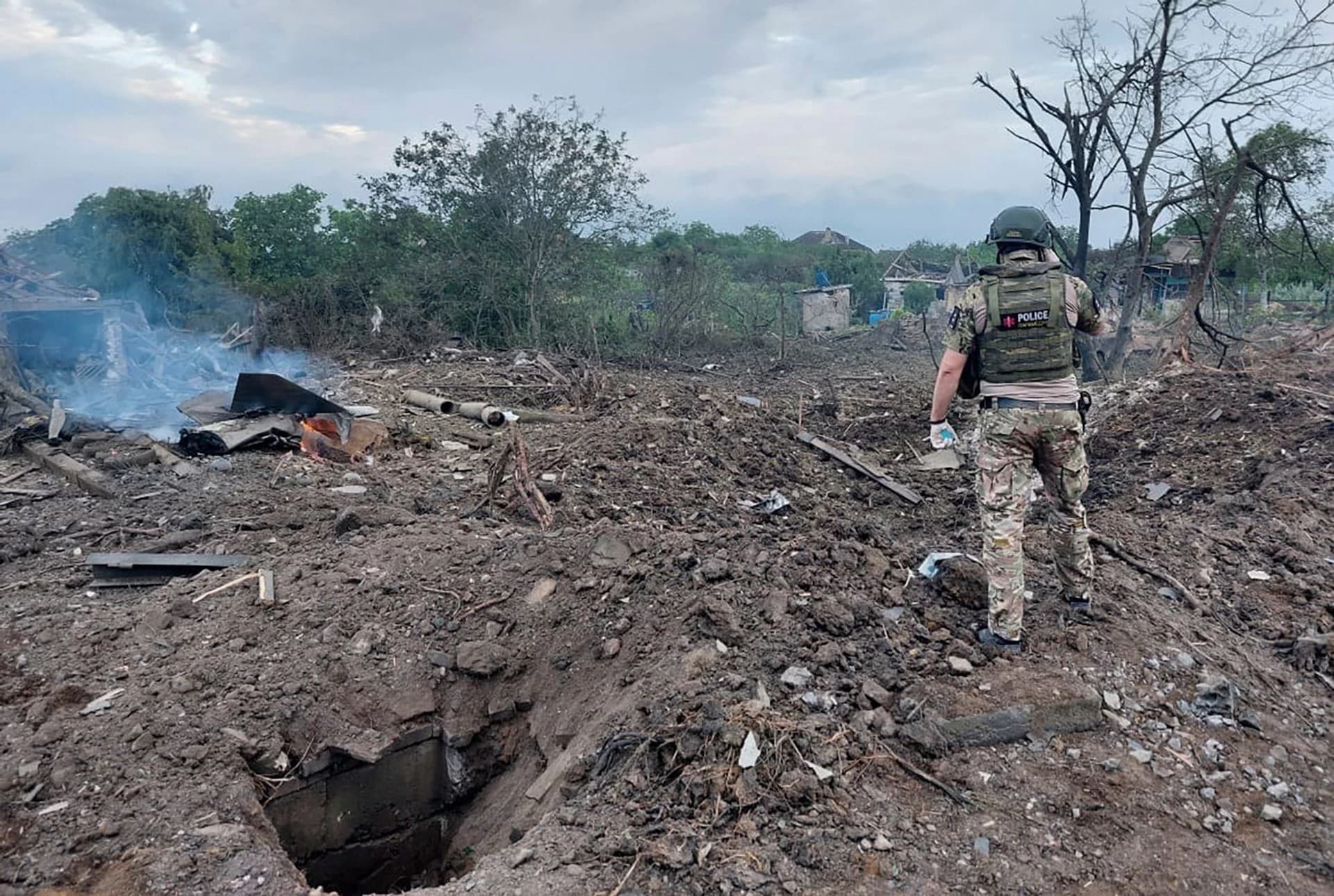 A Ukrainian police officer inspects the scene of the deadly morning Russian rocket attack in Kostyantynivka