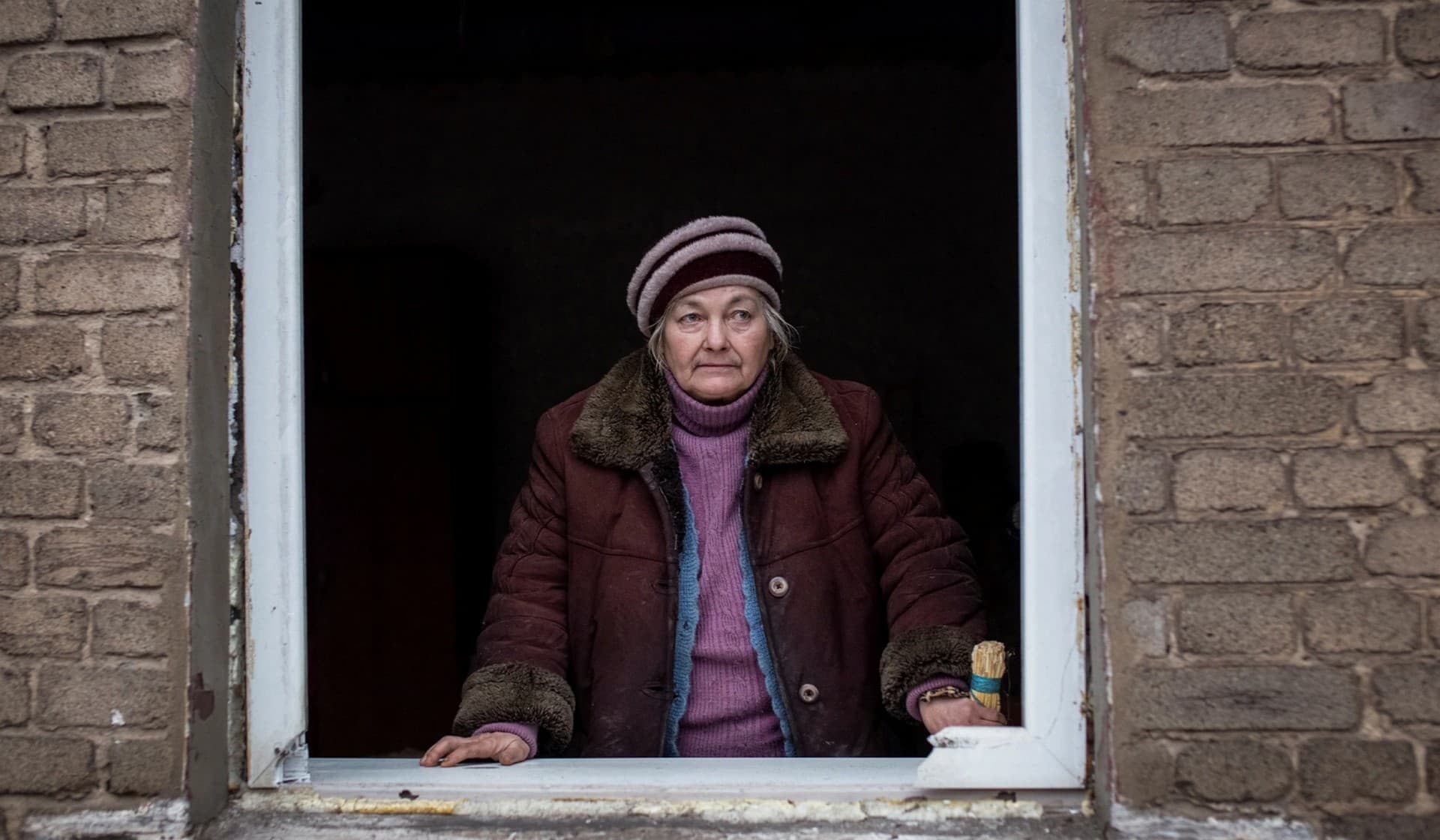 A local resident is seen in a window of her house that was destroyed by a Russian military strike in Kramatorsk