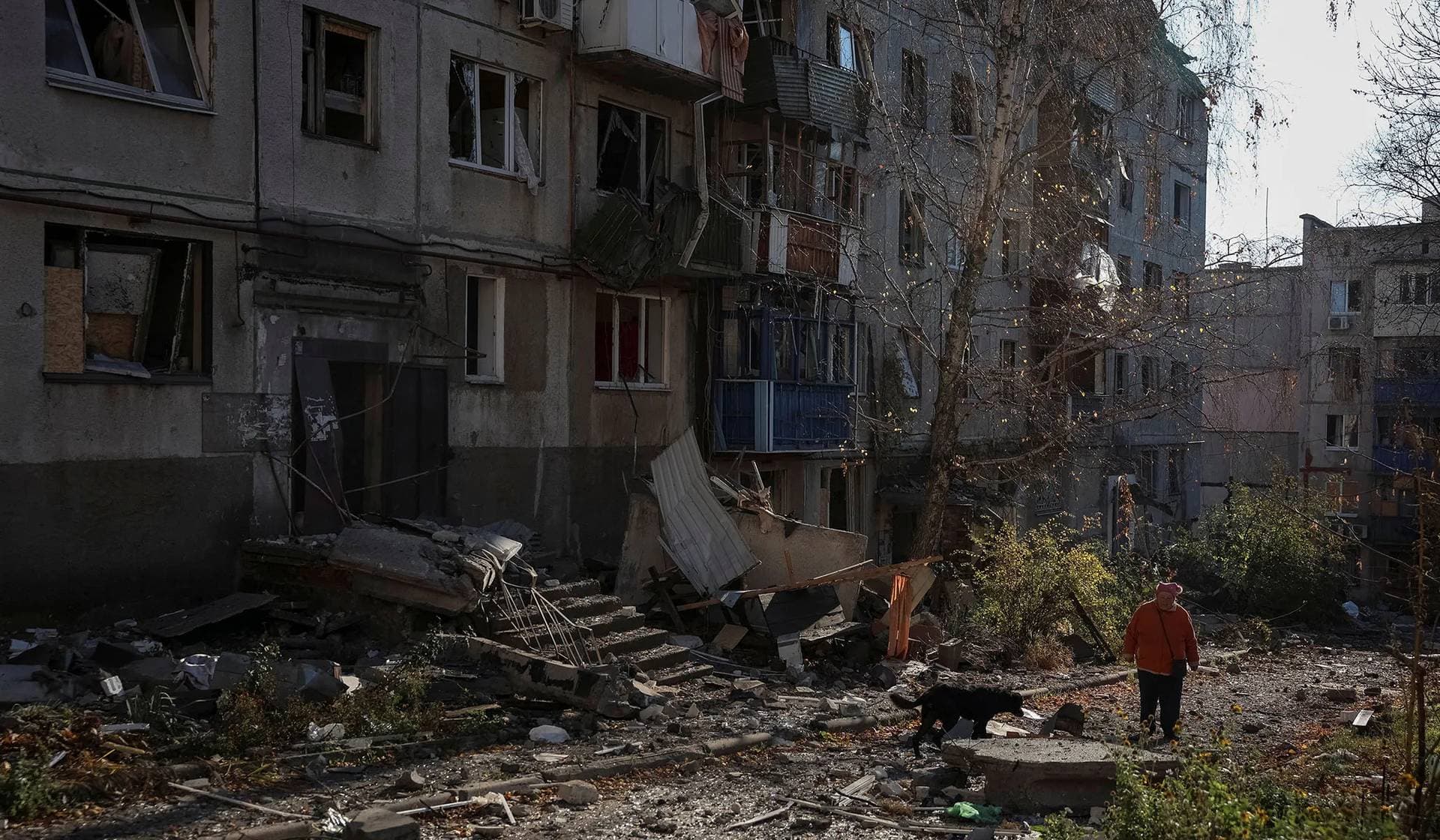 A resident walks near apartment buildings damaged by a Russian military strike in the frontline town of Kostiantynivka