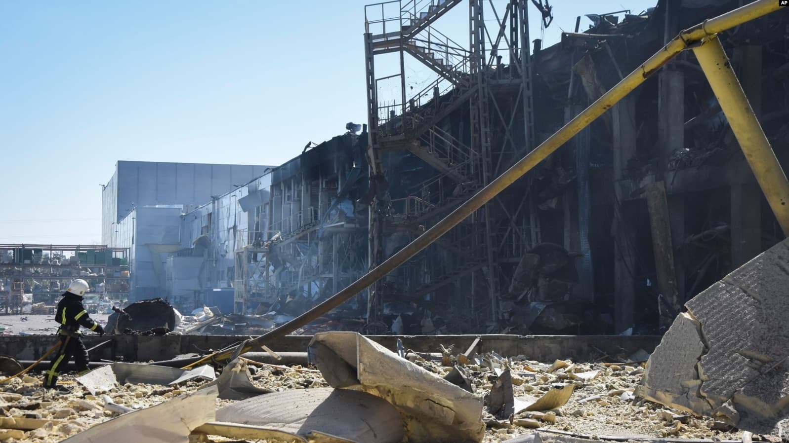 An Ukrainian firefighter works near a destroyed building on the outskirts of Odesa