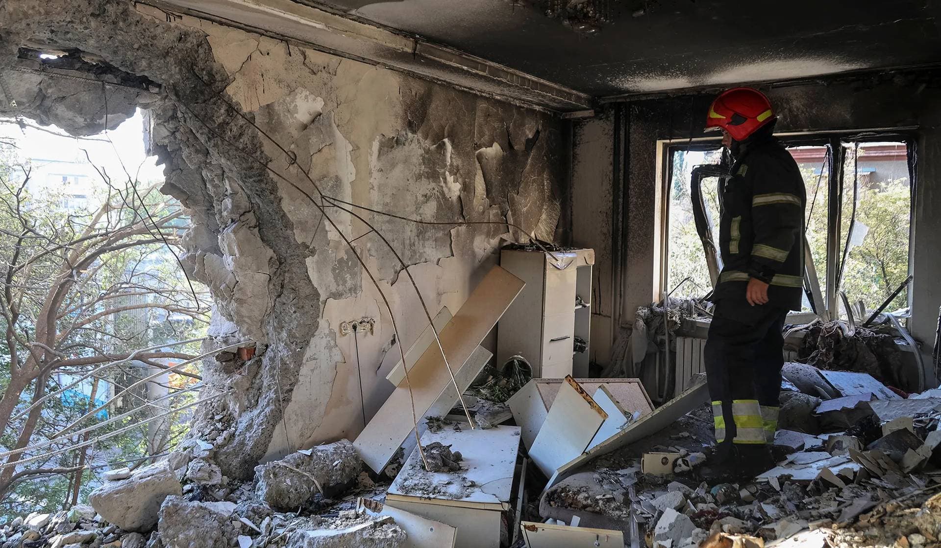 A firefighter inspects an apartment in a building damaged by a Russian drone strike in Odesa
