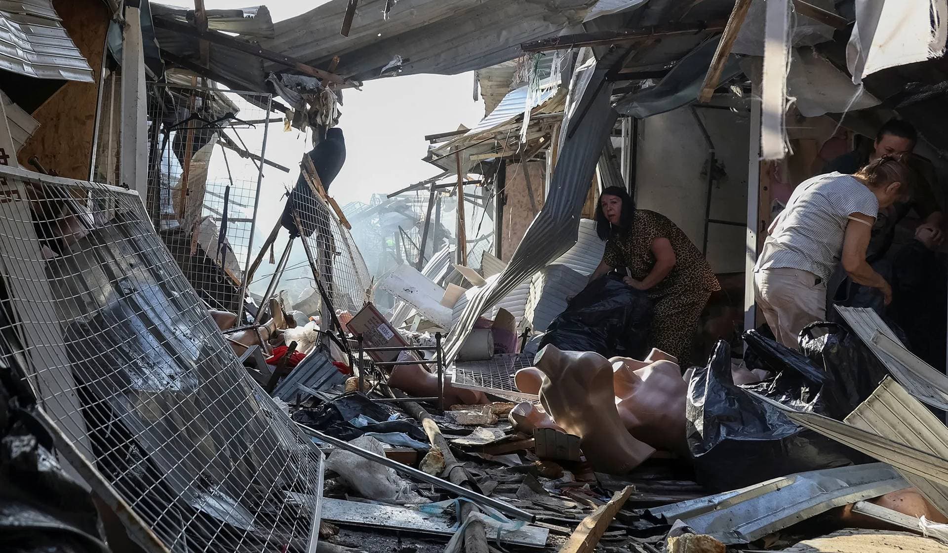 Employees sort clothes at a market which was hit by a Russian drone strike in Odesa