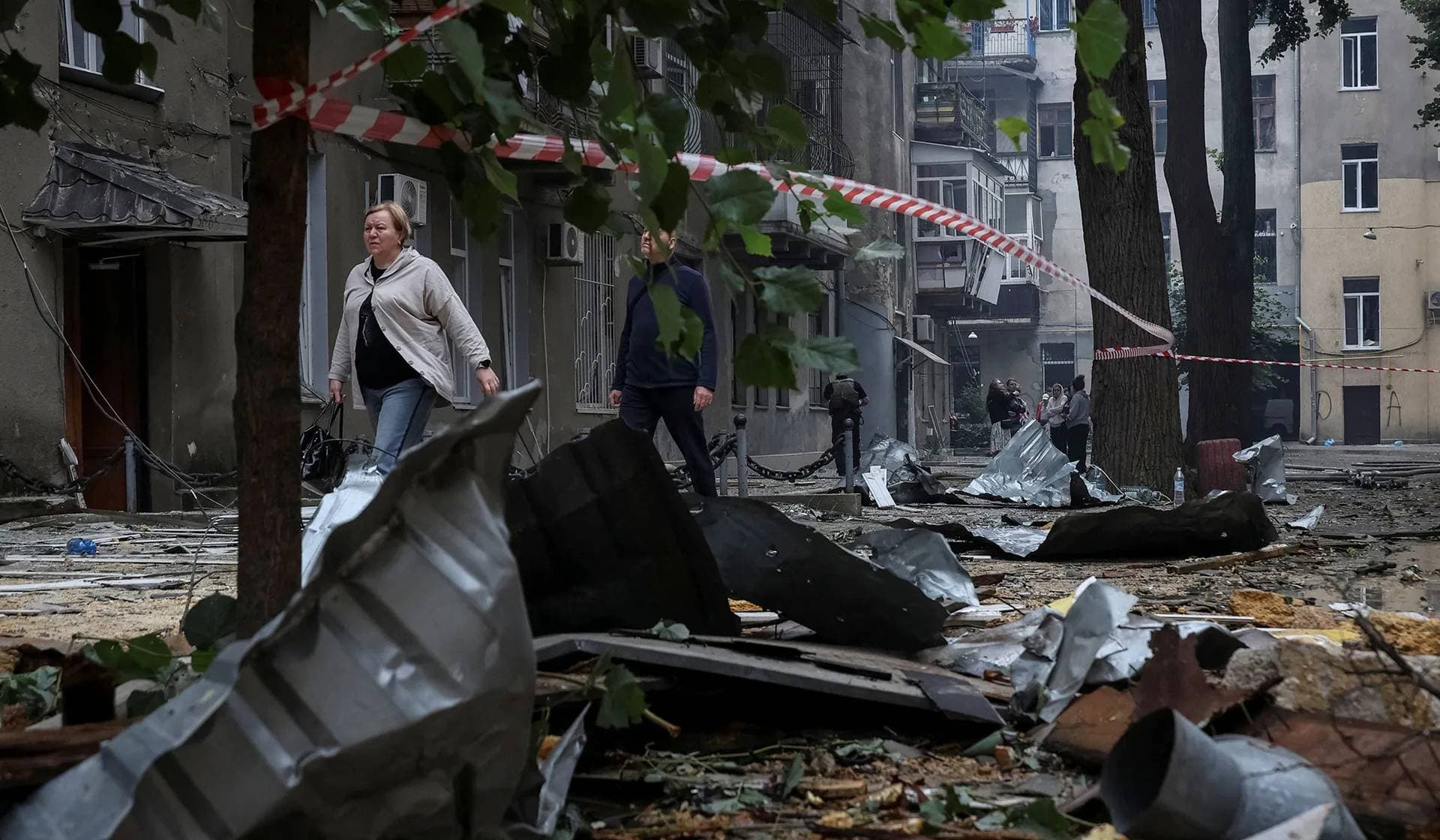 Residents walk at the site of a Russian drone strike in Odesa