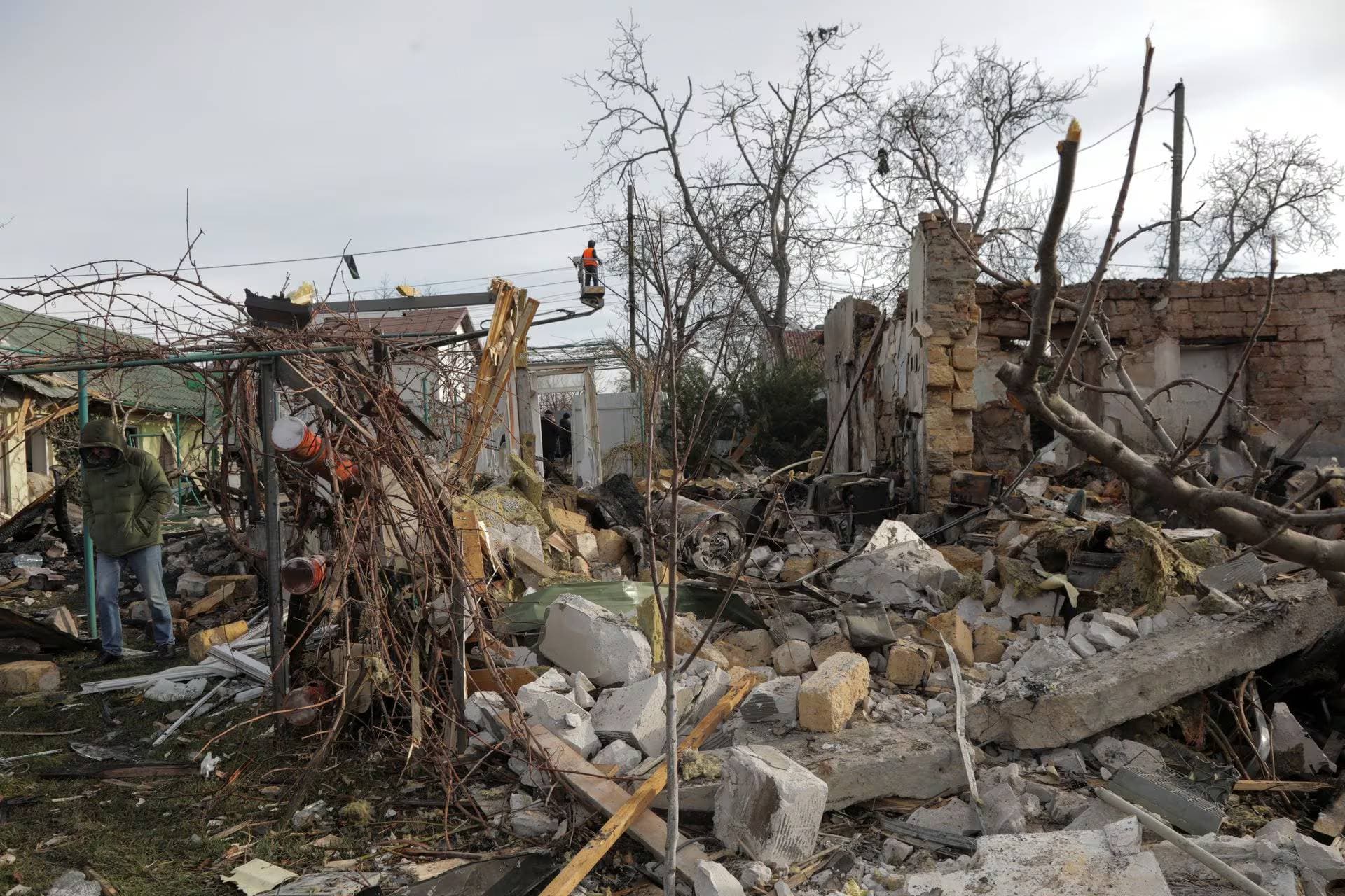A local resident walks at a site of a residential building destroyed during a Russian drone strike in Odesa