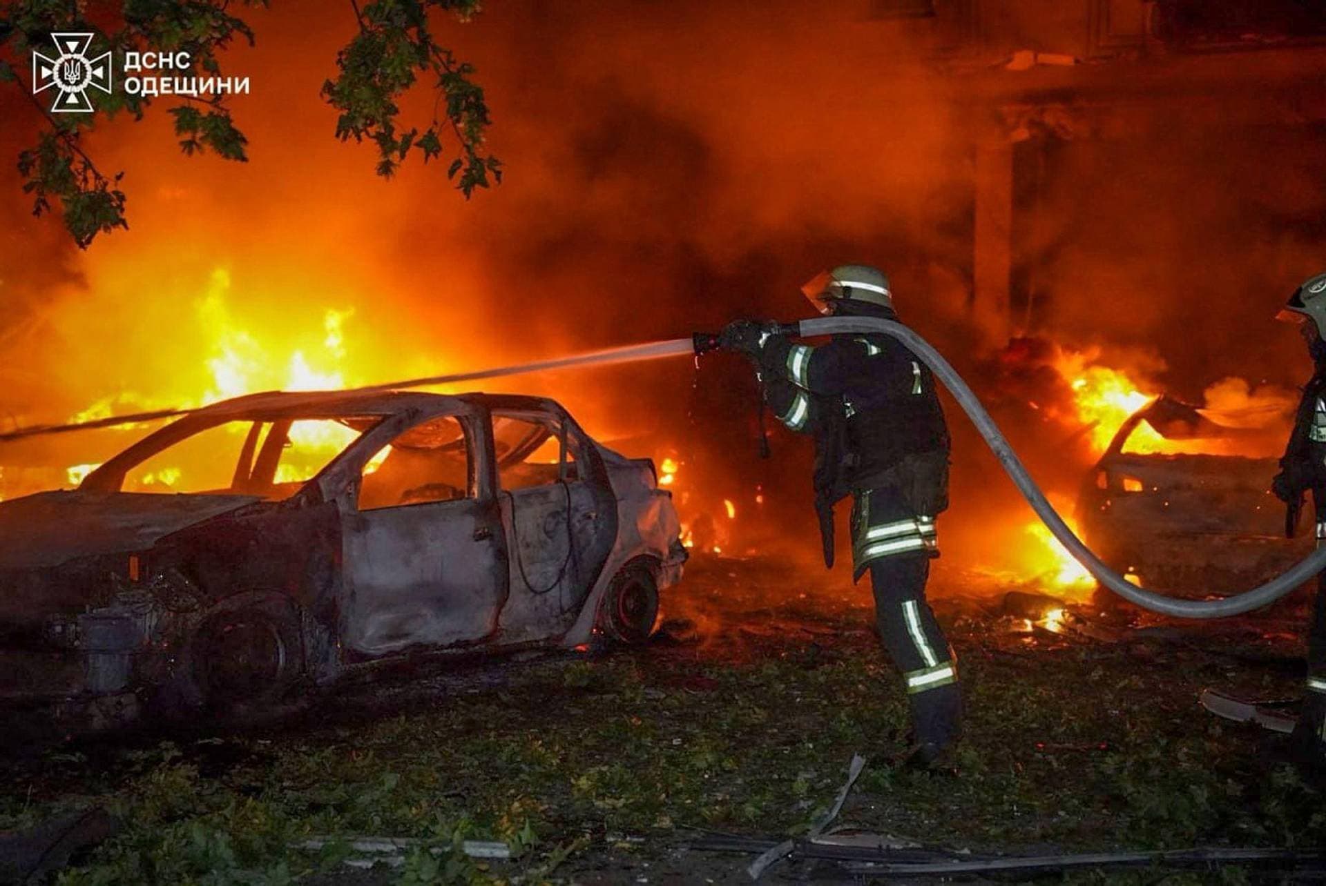 A firefighter extinguishes burning cars at a parking lot after a Russian drone strike in Odesa