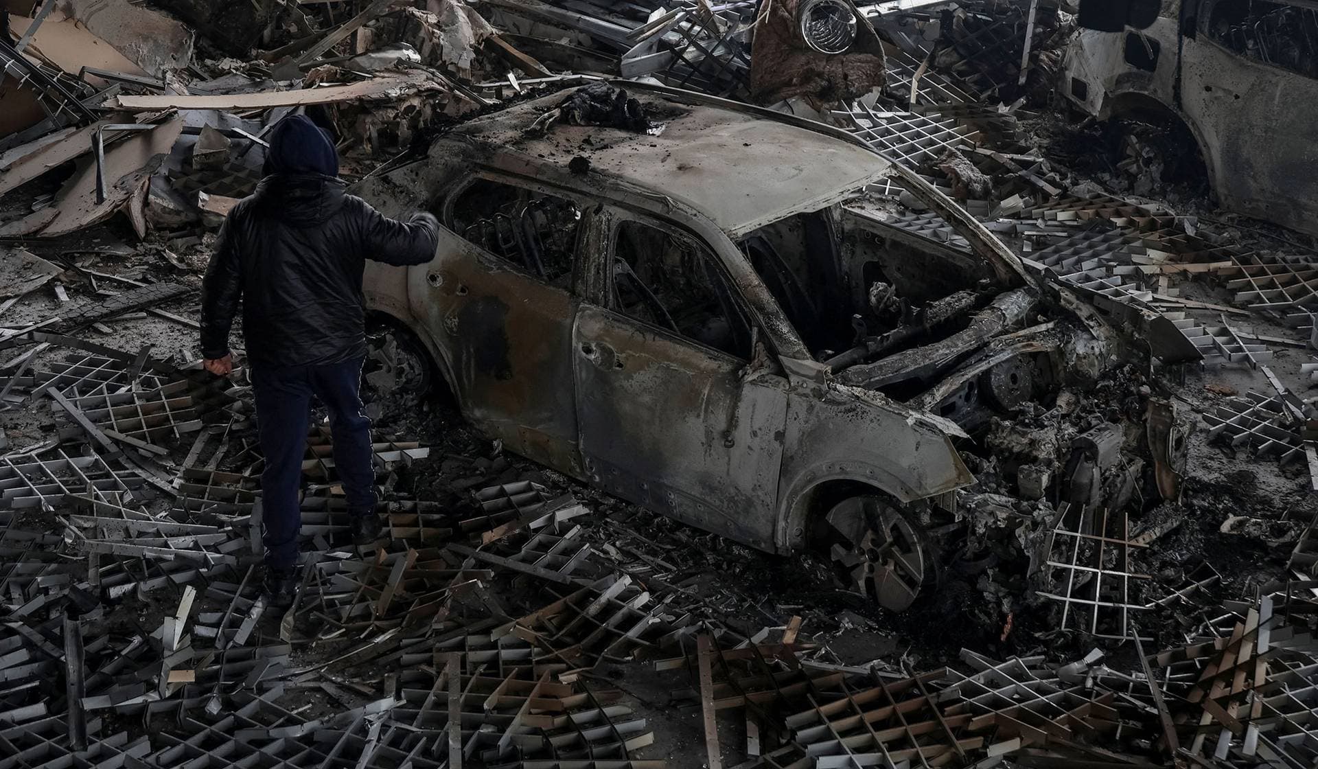 A man inspects a damaged car at the site of a Russian drone strike in Odesa