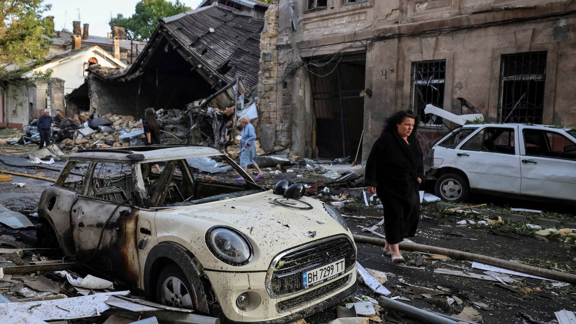 Residents walk at the site of an apartment building hit by a Russian drone strike in Odesa