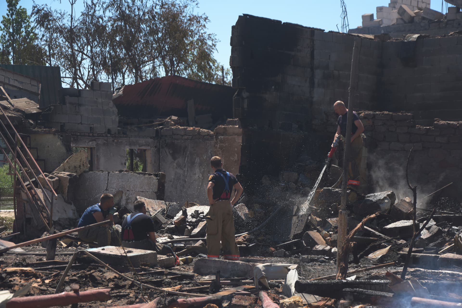 Firefighters work at a damaged residential building following Russian shelling on the outskirts of Odesa