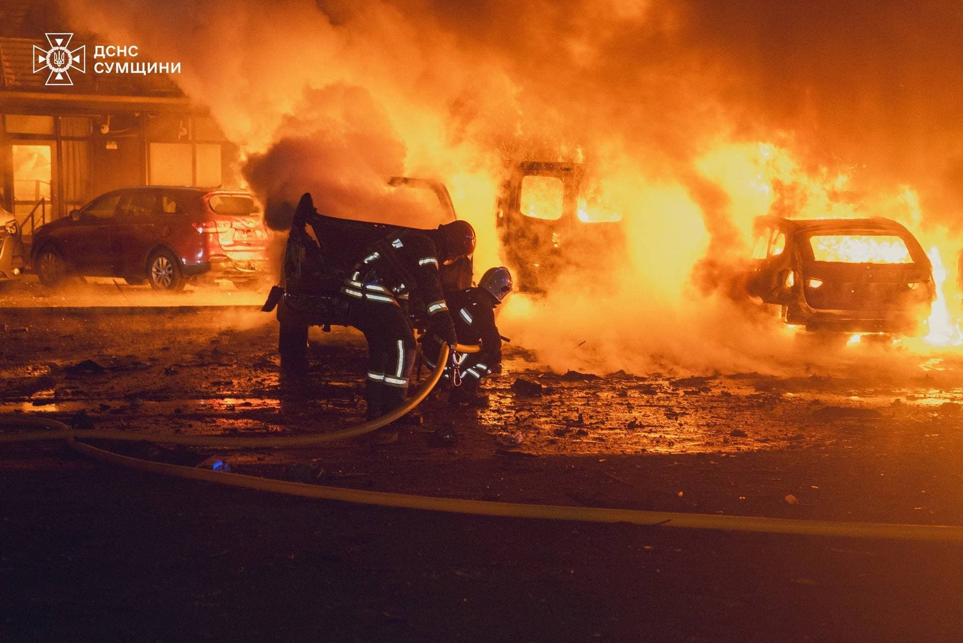 Firefighters work at a site of a residential area hit by a Russian drone strike in Sumy